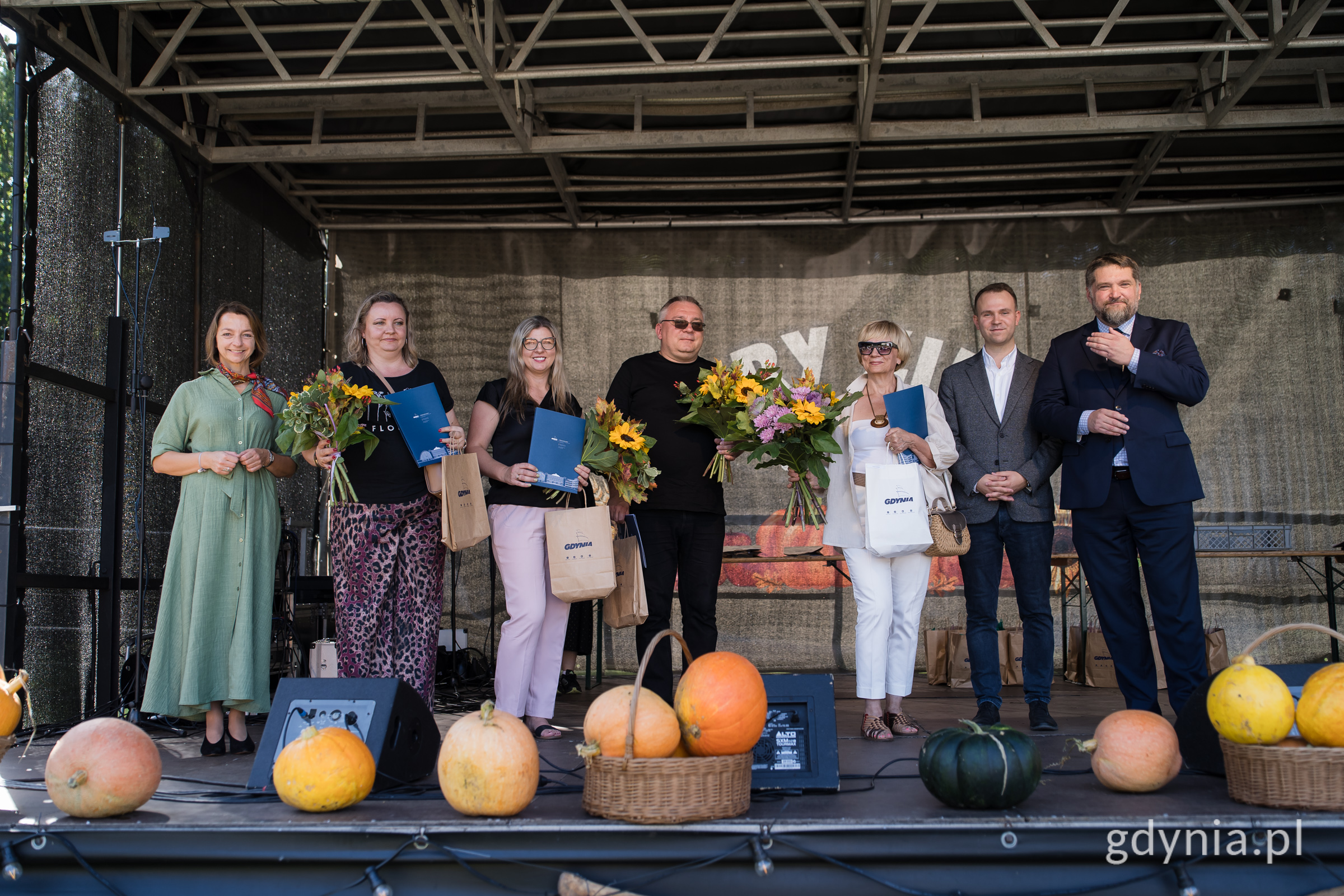 Ludzie na scenie z kwiatami