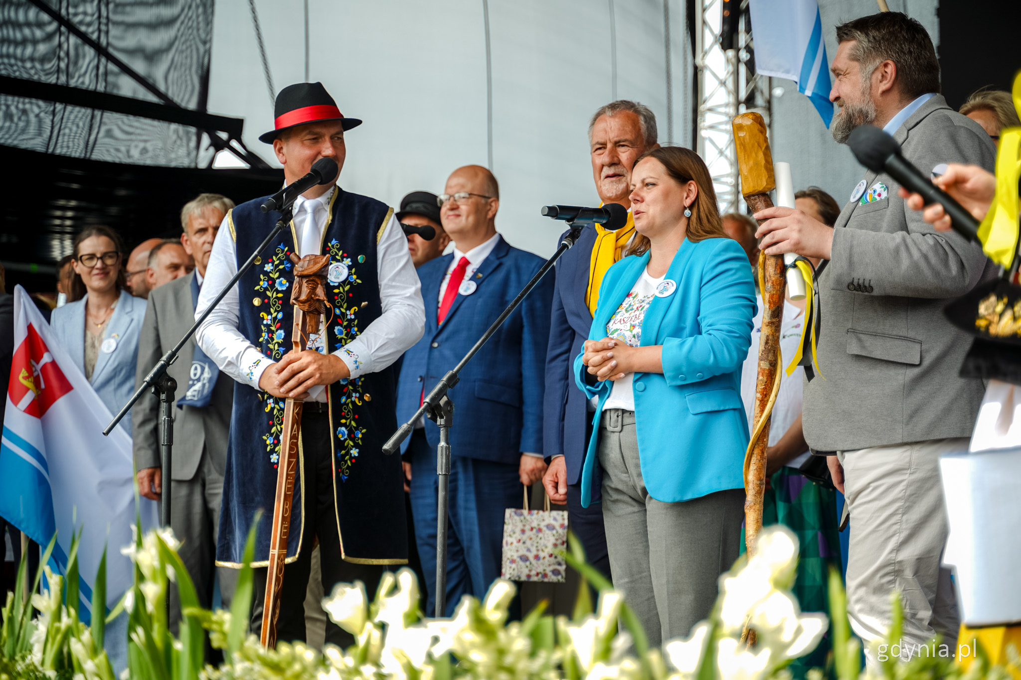 Scena w Szemudzie, grupa os&oacute;b na scenie, przy mikrofonach przemawia Aleksandra Kosiorek, obok Ryszard Kalkowski i Tadeusz Szemiot