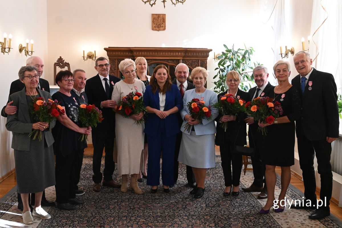 Seniorzy stojący w eleganckiej sali