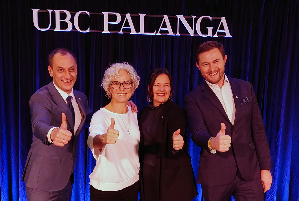 Dwie kobiety i dw&oacute;ch mężczyzn usmiecha się i pokazuje kciuk w g&oacute;rę.