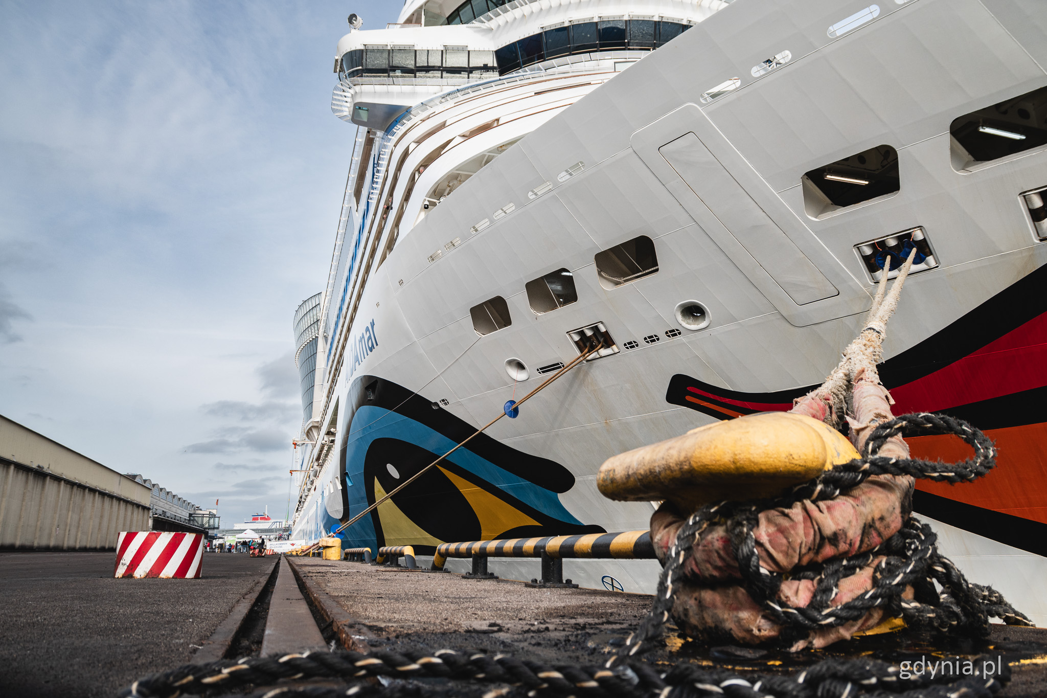 Nabrzeże Francuskie w Gdyni, budynek po lewej, po prawej cumujący statek wycieczkowy