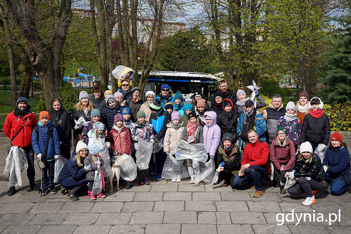 Grupa dzieci, dorosłych i młodzieży z przygotowanymi workami na śmieci