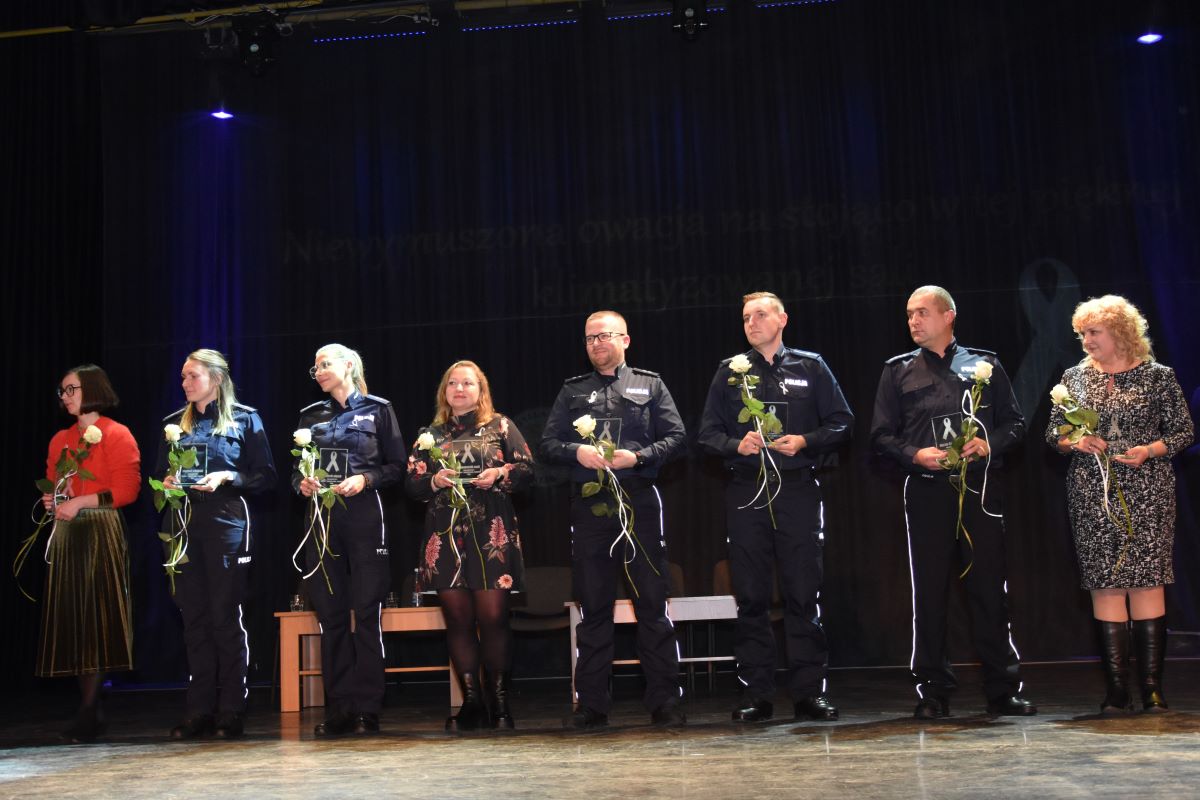 Zdjęcie przedstawia ambasador&oacute;w kampanii Biała Wstążka odbierających pamiątkowe statuetki symbolizujące docenienie ich codziennych wysiłk&oacute;w w zapobieganiu zjawisku przemocy. 