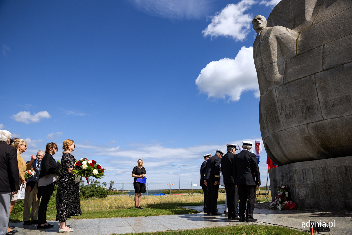 Ludzie składają kwiaty pod pomnikiem Josepha Conrada.