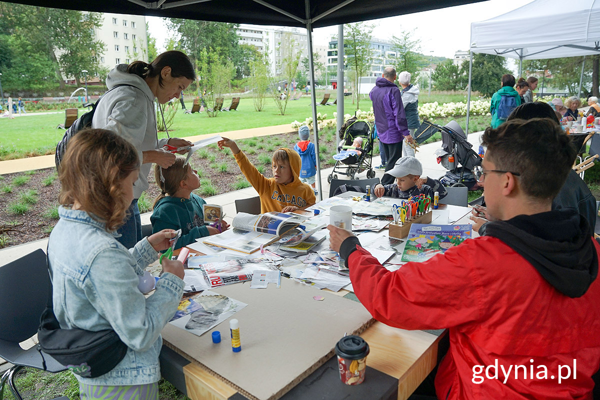 Park Centralny, namiot, grupa dzieci bawi się na stole, edukatorzy, w tle drzewa i park