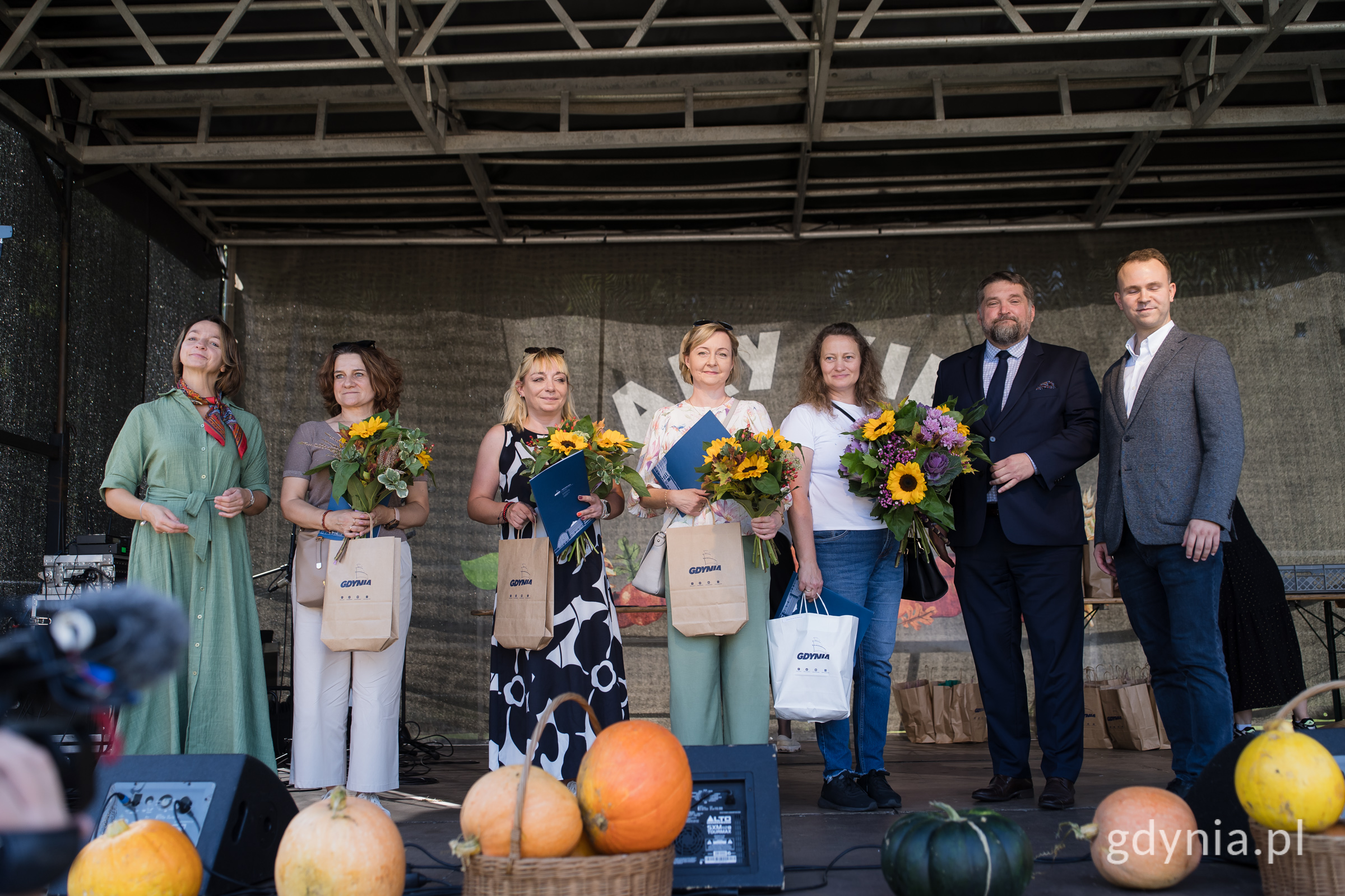 Ludzie na scenie z kwiatami