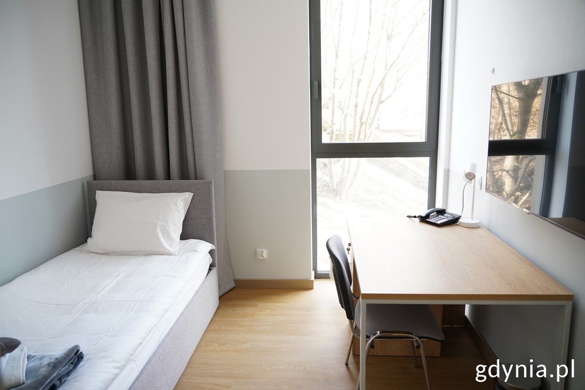 Jeden z pokoi dla kursant&oacute;w AMW z ł&oacute;żkiem z stolikiem