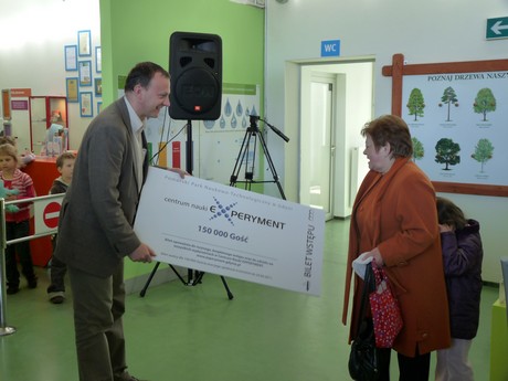 150-tysięczny gość Centrum Nauki Experyment - wiceprezydent Gdyni Michał Guć wręcza całoroczny bilet do placówki