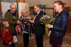 Pani Małgorzata Grzeszczak z rodziną otrzymuje album o Gdyni z okazji 100.000 sobotniego interesanta w gdyńskiej Sali Obsługi Mieszkańców, fot. Michał Puszczewicz