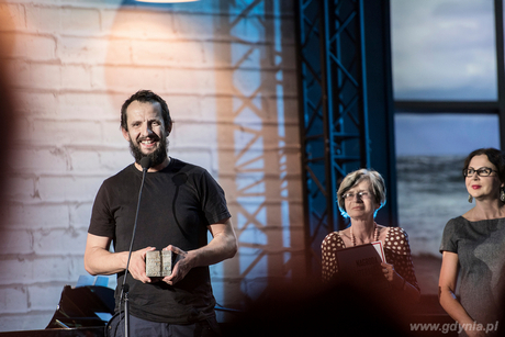 Laureat Nagrody Literackiej Gdynia 2016 Michał Książek ze statuetką Kostką Literacką, fot. mat. prasowe Nagrody Literackiej Gdynia