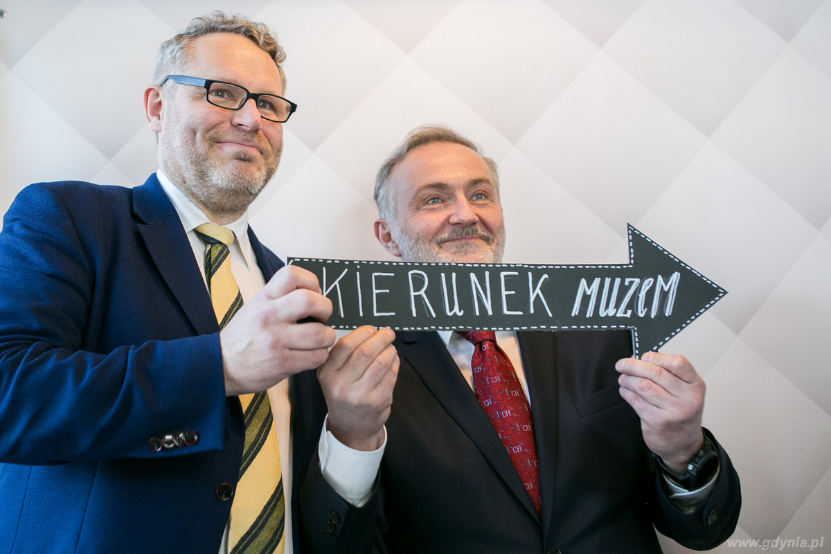 Dyrektor Muzeum Miasta Gdyni Jacek Friedrich i prezydent Gdyni Wojciech Szczurek trzymają wspólnie strzałkę z napisem kierunek muzeum na otwarciu nowej wystawy stałej Muzeum Miasta Gdyni, fot. Karol Stańczak