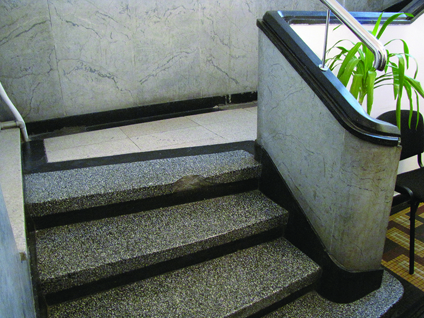 Początek schodów w kamienicy przy ul 10 Lutego 5. Dekoracyjny początek ciągu schodów wykonanych z lastryka, o odmiennej barwie stopnic, podstopnic oraz spocznika.