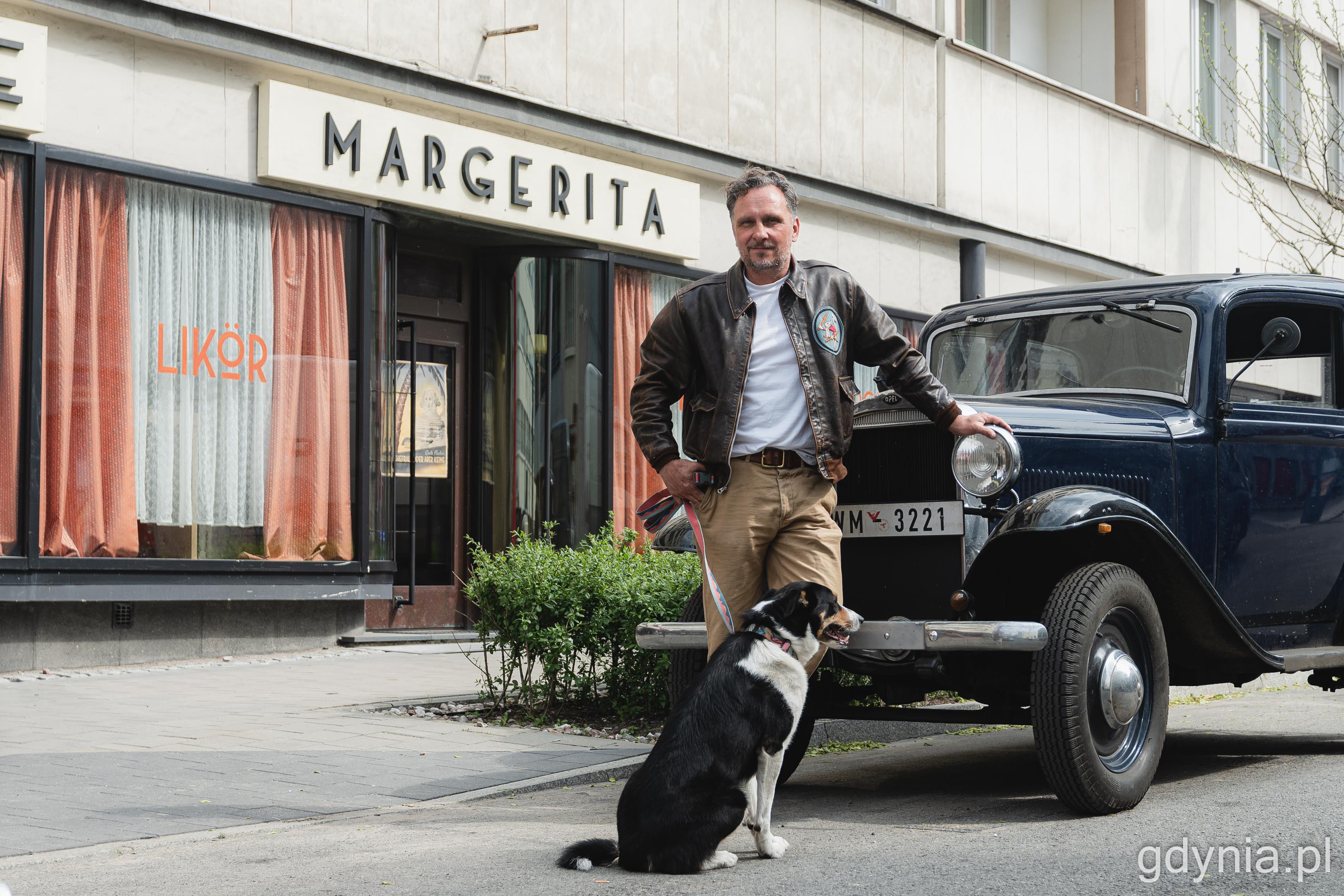 Na zdj. Michał Rogalski stoi oparty o zabytkowe auto przed kawiarnią Cyganeria, która na moment zmieniła się w Margeritę 