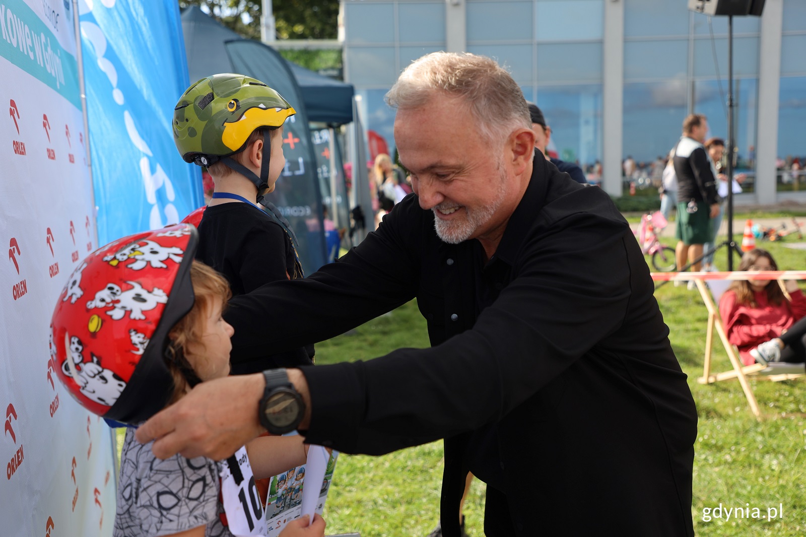 Prezydent Gdyni Wojciech Szczurek wręczający medale dzieciom