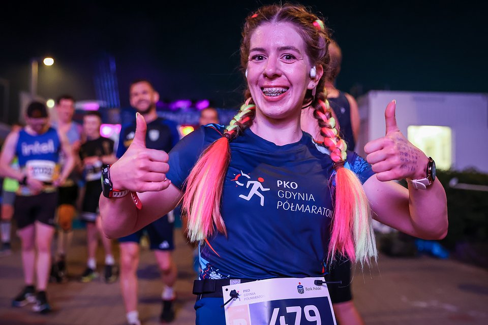 Uśmiechnięta kobieta na mecie PKO Gdynia Półmaraton