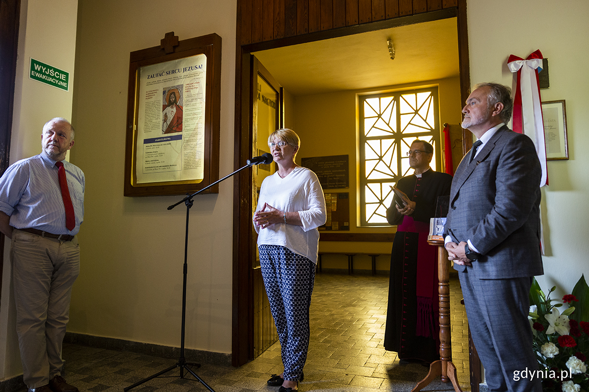 W przedsionku kościoła stoją cztery osoba, przemawia kobieta.