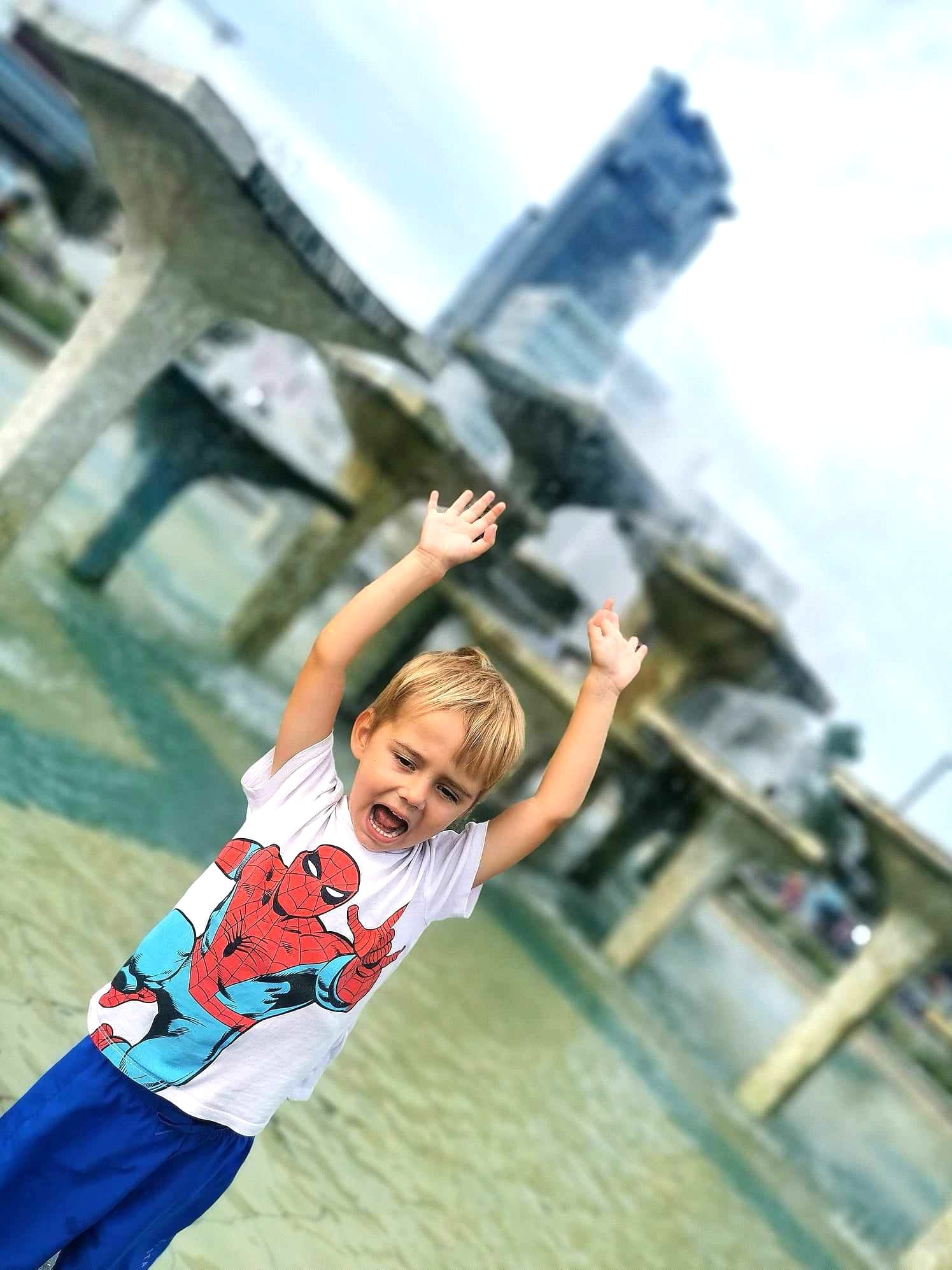 Chłopiec pozujący przed fontanną
