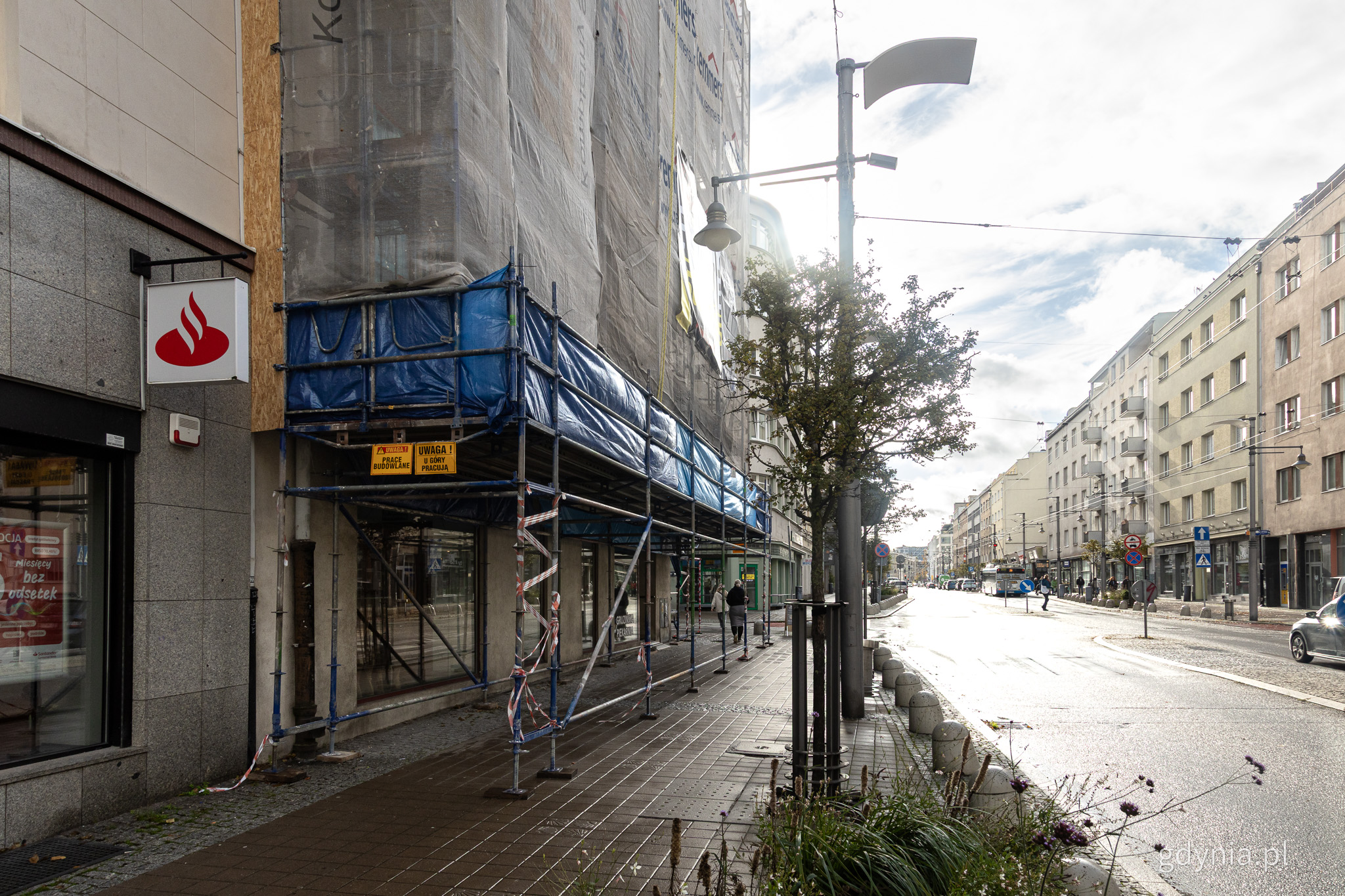 Rusztowania, ulica Świętojańska, okryta elewacja jednej z kamienic, widoczna ulica i chodnik