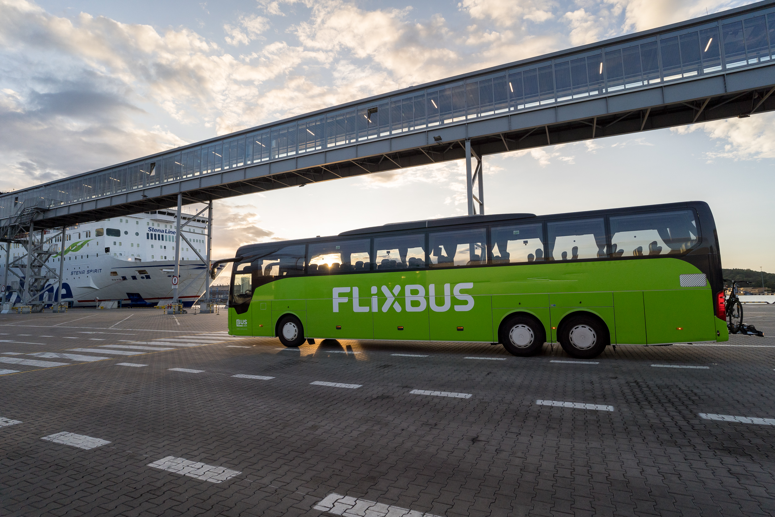 Autobus FlixBus na przystani promowej, obok stoi prom.