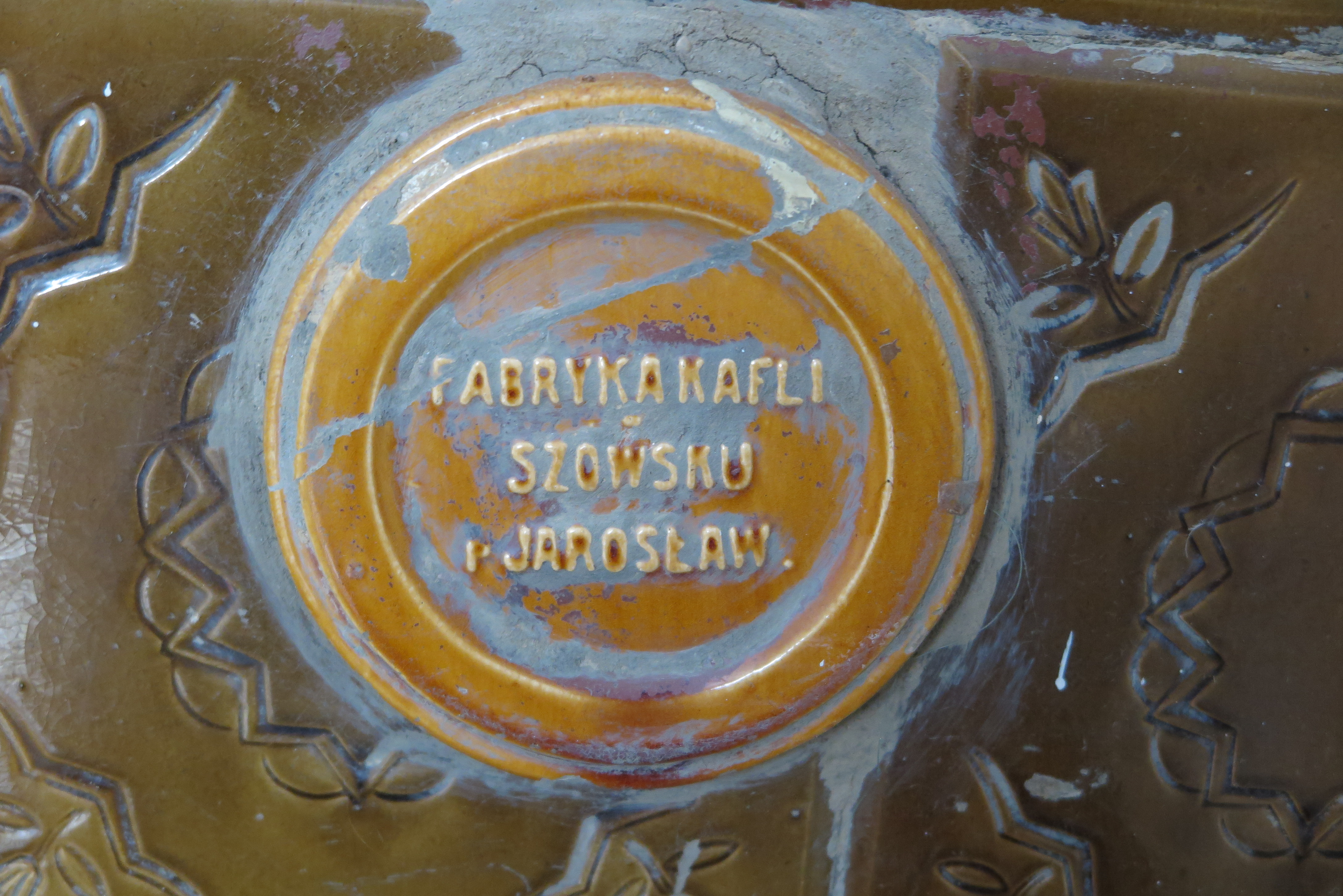 Detal pieca z nazwą producenta w jednym z domów przy ul. Słupeckiej na Działkach Leśnych