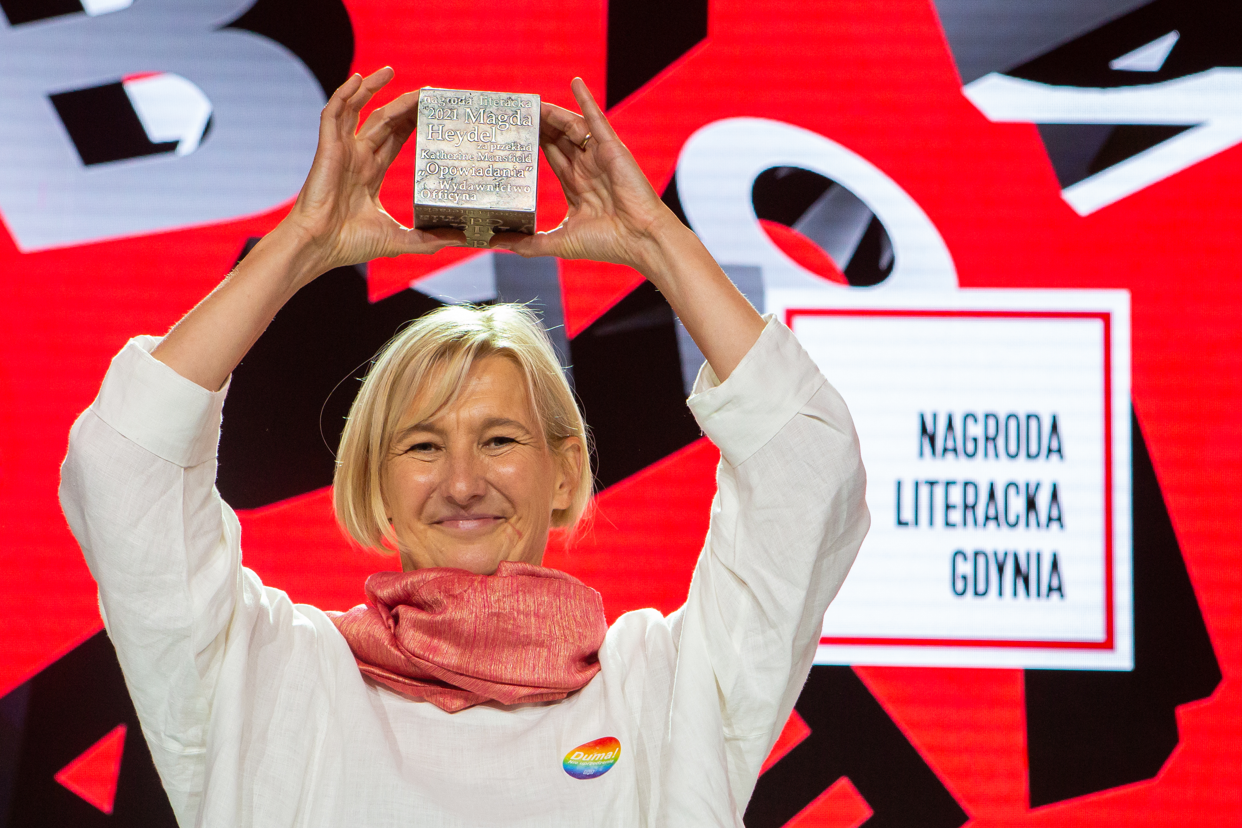 Magda Heydel  laureatka Nagrody Literackiej Gdynia w kategorii przekład na język polski. Ma uniesione ręce, w których trzyma Kostkę Literacką // fot. Anna Rezulak