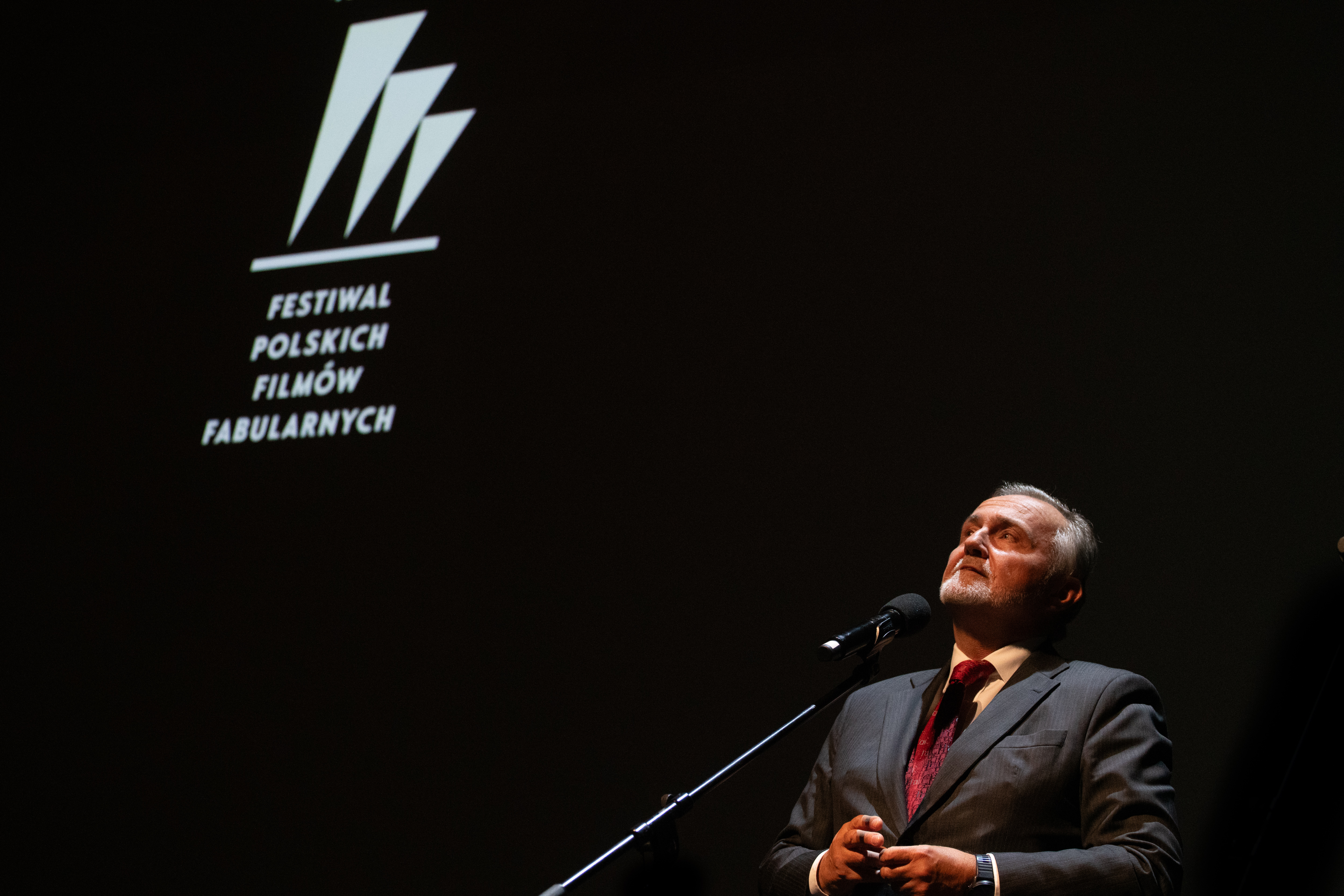 Ciemna scena Teatru Muzycznego, logo FPFF, Wojciech Szczurek przemawia przez mikrofon