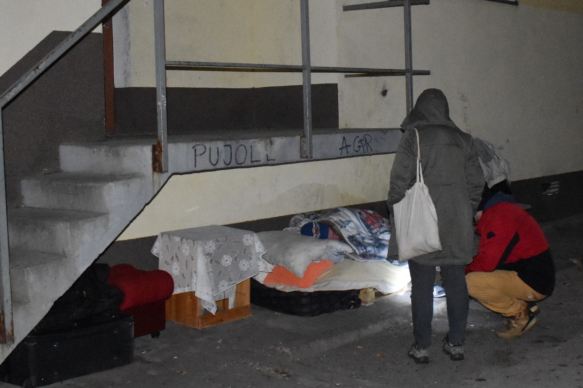 Zdjęcie pokazuje pracowników socjalnych zachęcających osobę bezdomną do skorzystania z miejsca w noclegowni.