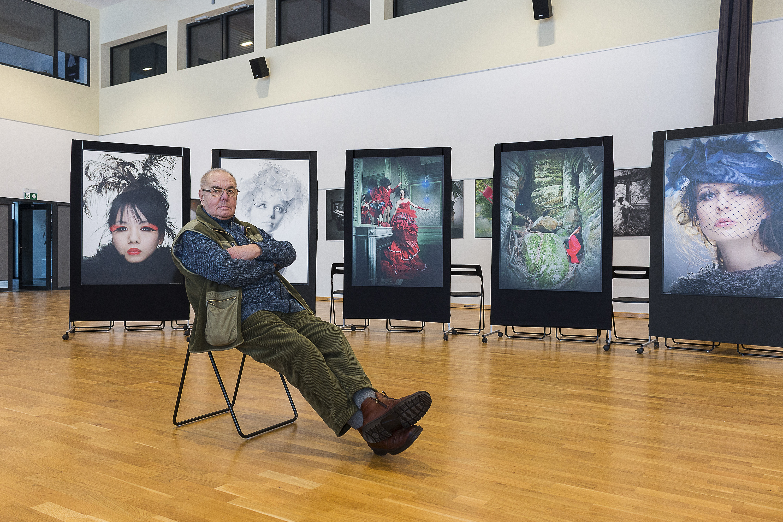 Mirosław Araszewski siedzi na sali pośród swoich fotografii // fot. Jacek Paluchowski
