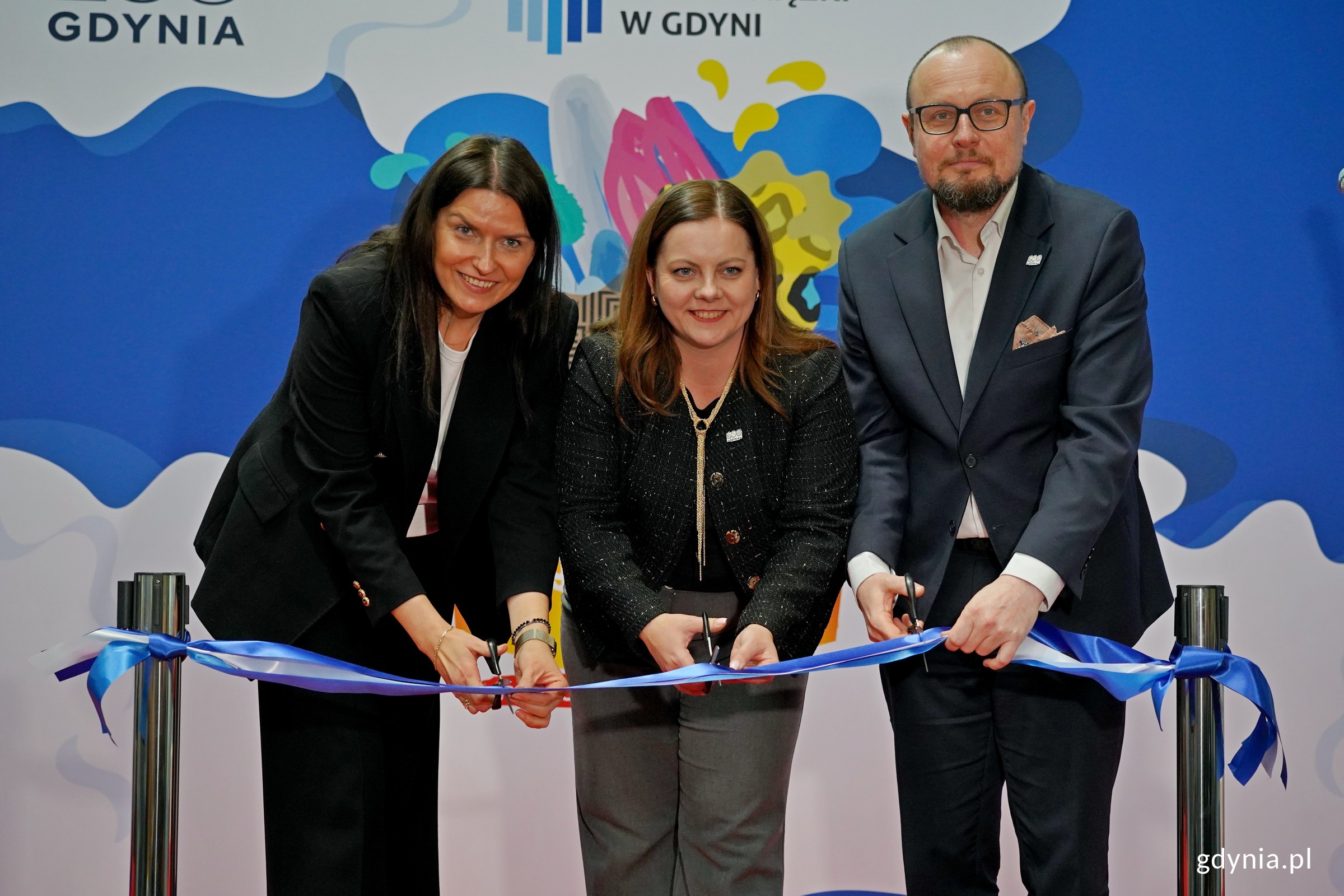 Od prawej: Mariusz Bzdęga &ndash; dyrektor zarządzający ds. kultury i aktywności mieszkańc&oacute;w Urzędu Miasta Gdyni, prezydent Gdyni Aleksandra Kosiorek oraz Mariola Śrubarczyk-Cichowska &ndash; wiceprzewodnicząca Rady Miasta Gdyni podczas przecinania wstęgi na otwarciu Targ&oacute;w Książki w Gdyni (fot. Magdalena Czernek)