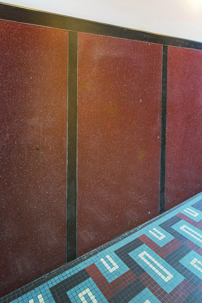 Fragment strefy wejściowej w kamienicy przy ul. 10 Lutego 5, w dolnej partii ścian dwukolorowe lastryko, posadzka utworzona z barwnych płytek tzw. irysków.