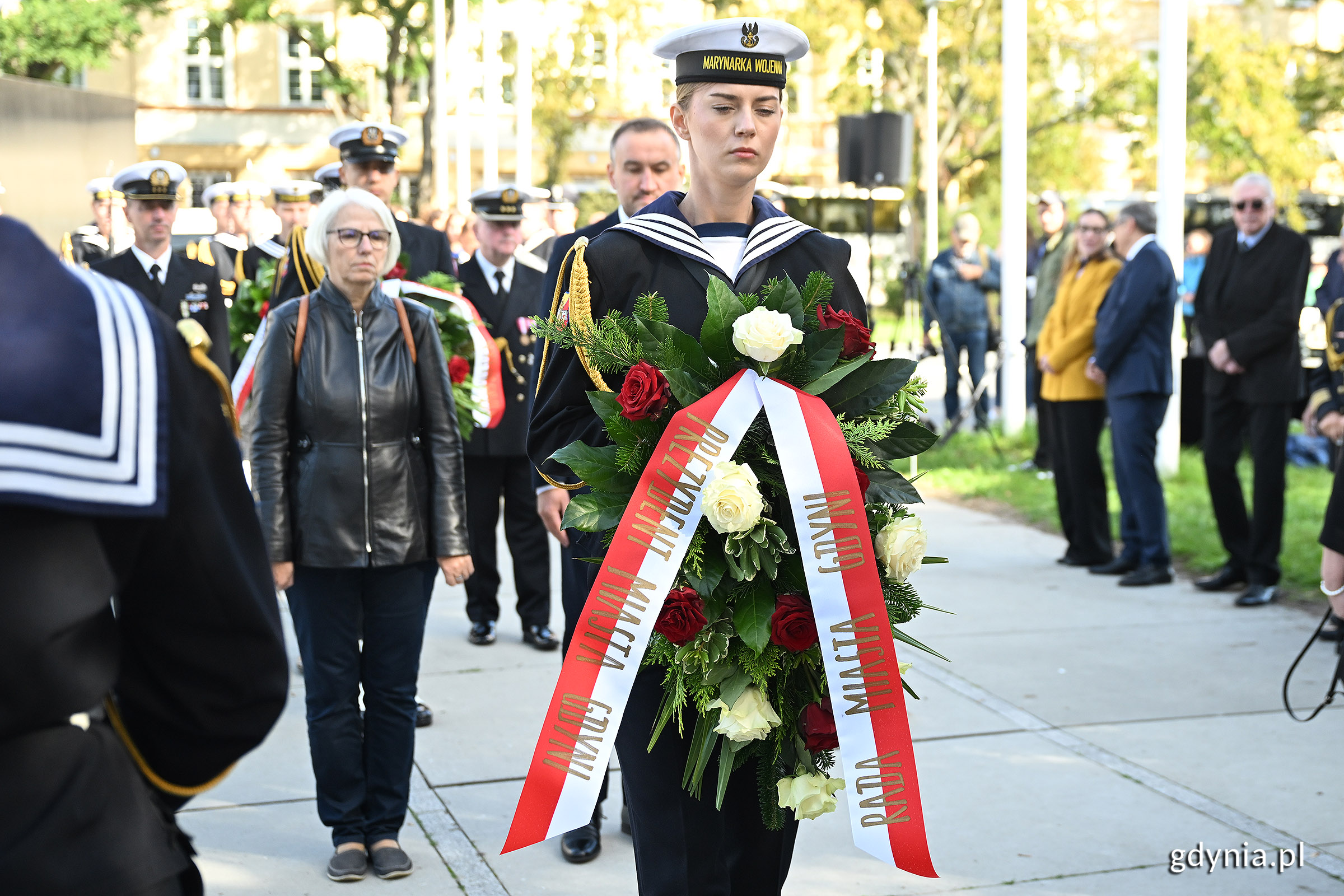 Żołnierz z wieńcem kwiatów, delegacja pod pomnikiem