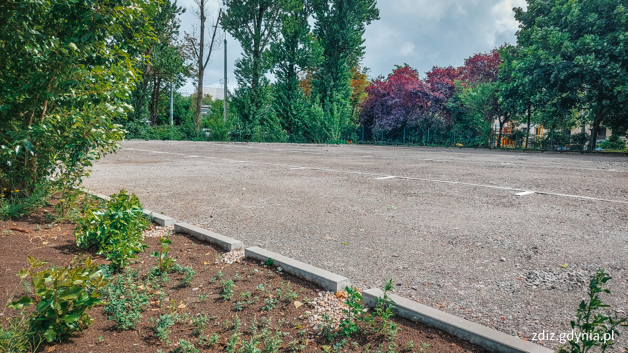 parking z nową nawierzchnię, widoczne szczeliny w krawężnikach umożliwiające spływ wód opadowych do gruntu