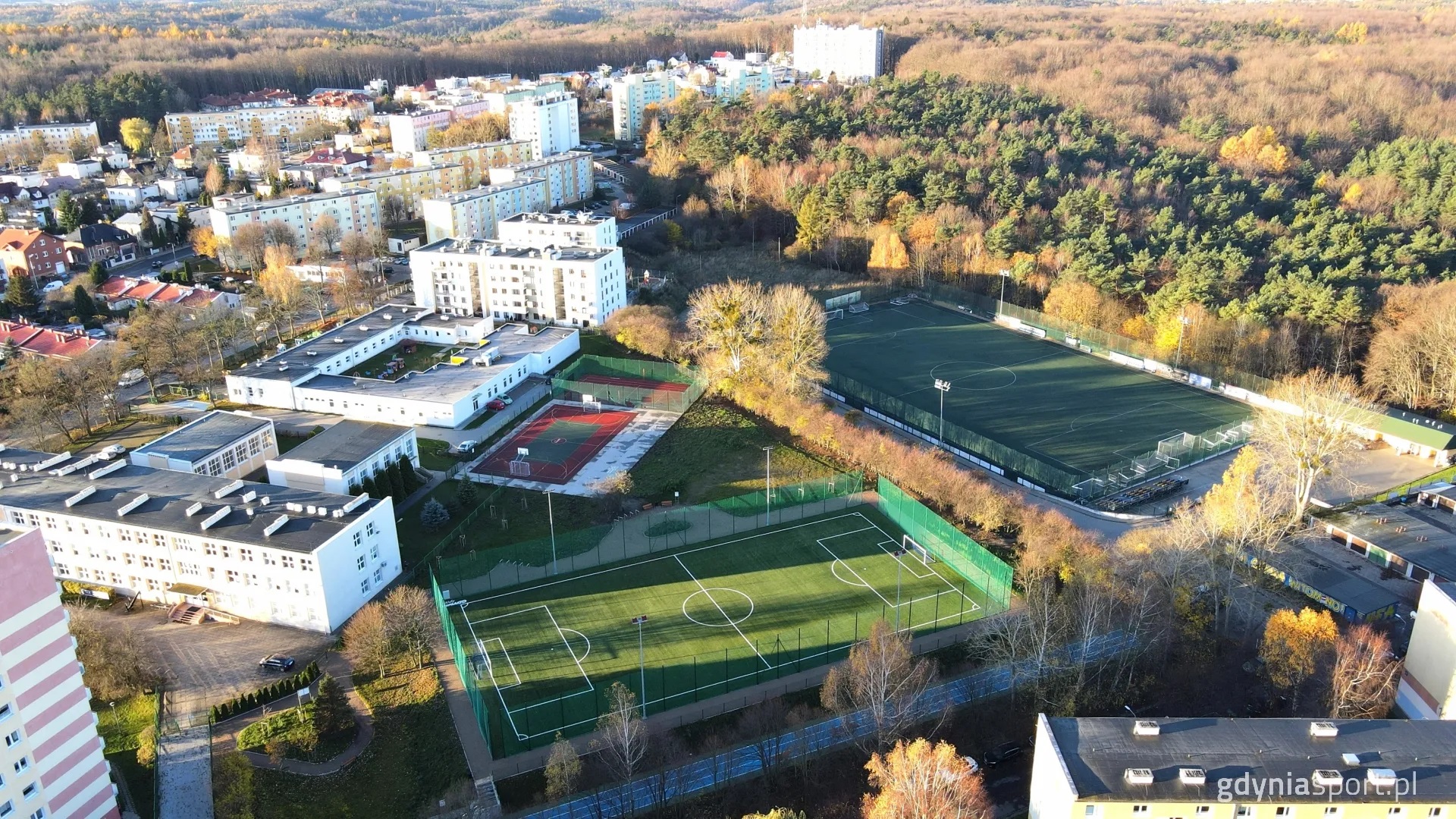 zdjęcie okolicy z lotu ptaka - boiska, budynki, las