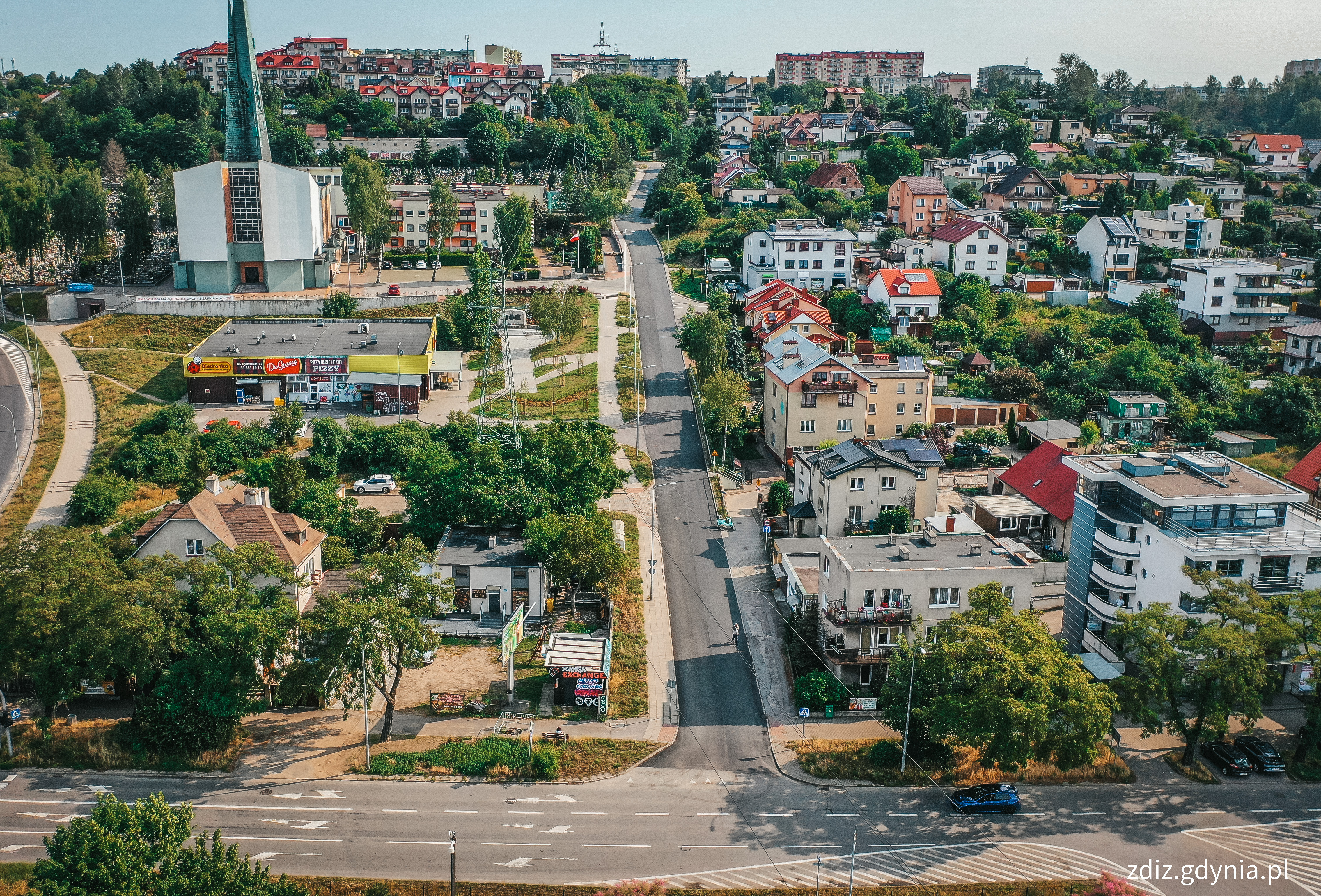 widok z góry na wyremontowaną nawierzchnię ul. Frezerów, w tle budynki, zieleń