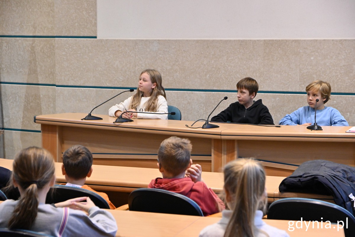 Uczniowie za stołem w sali obrad Urzędu Miasta Gdyni