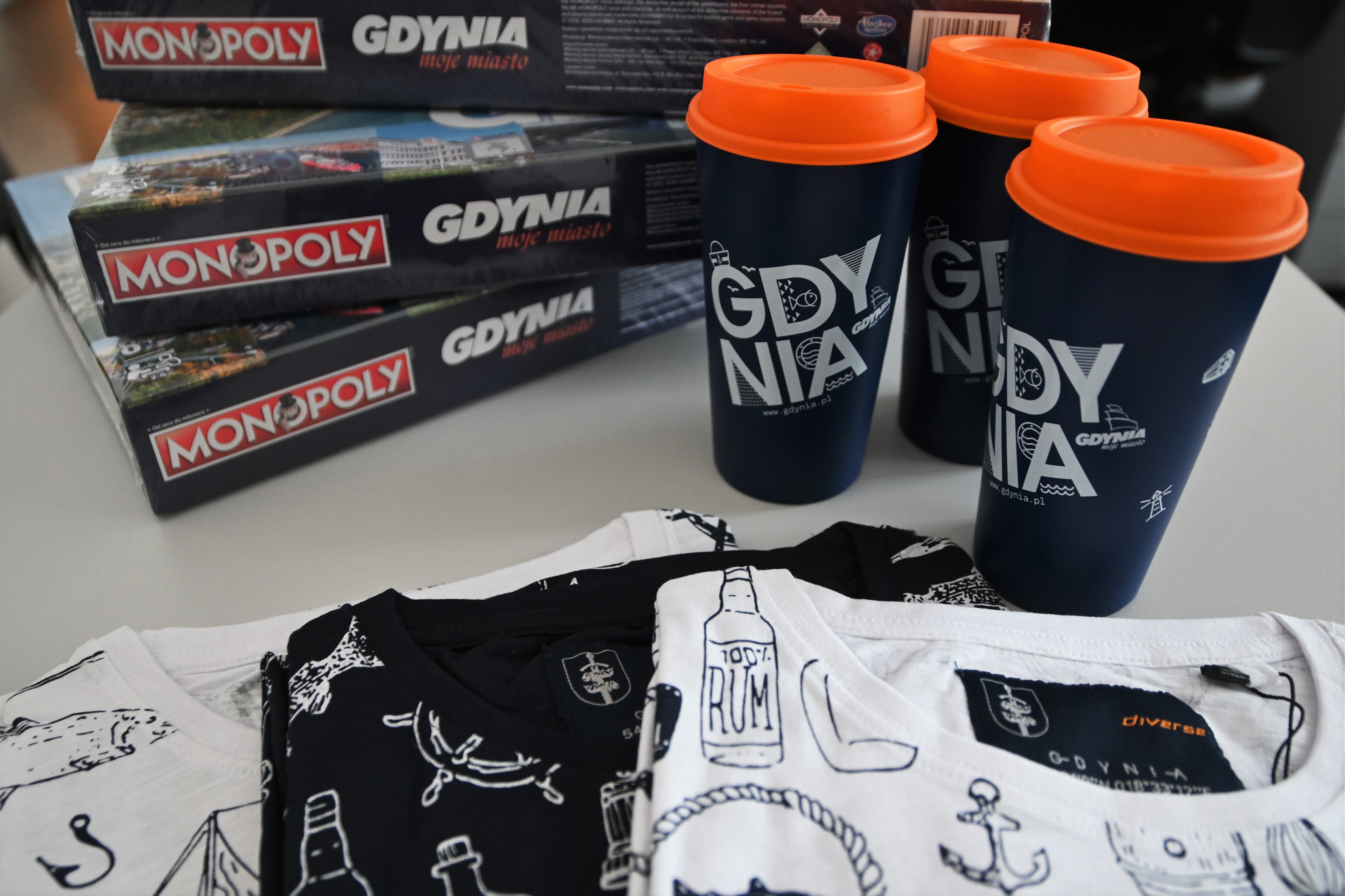 Gry planszowe "Monopoly Gdynia", kubki wielorazowe, koszulki z gdyńskimi motywami.