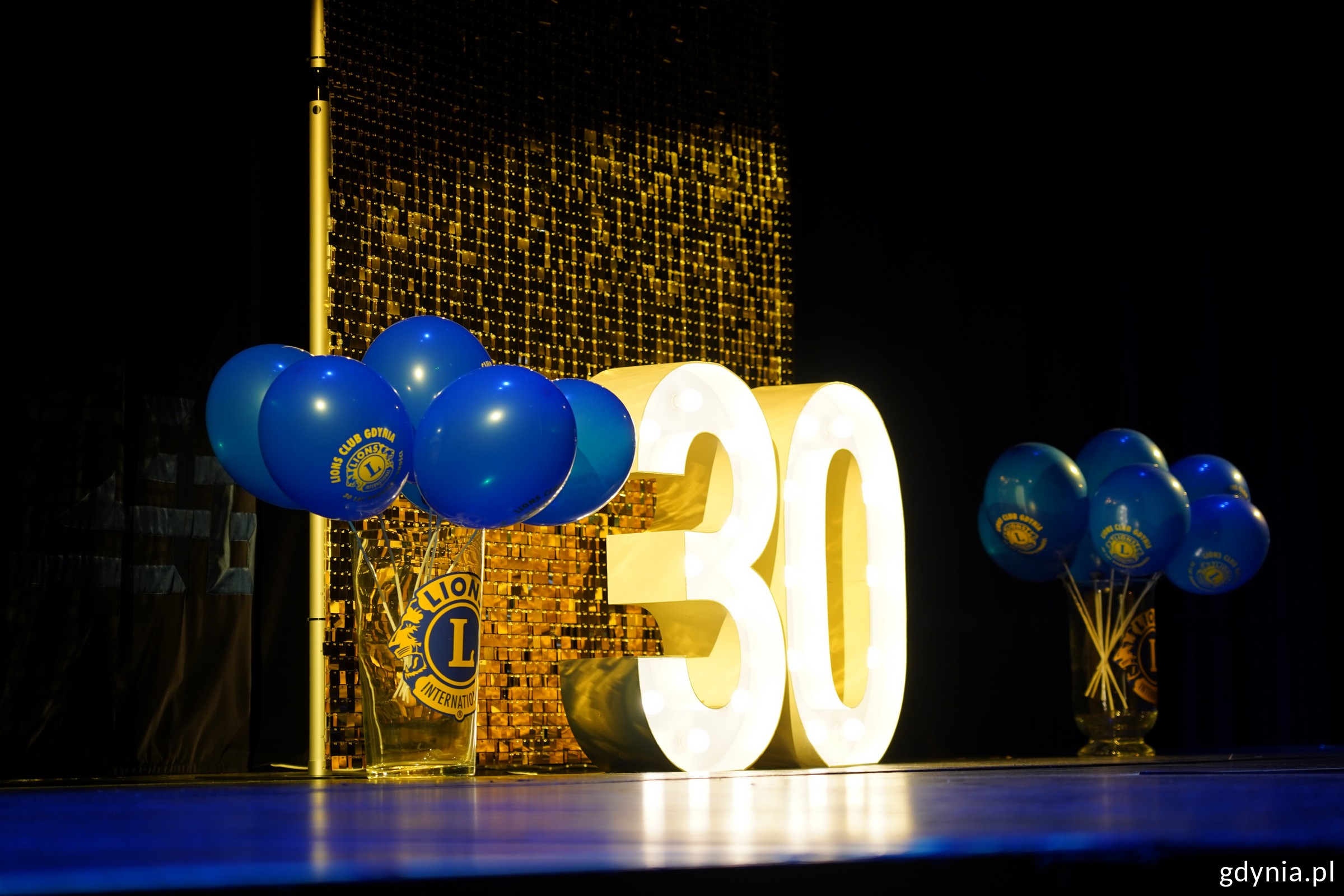 Dekoracja na scenie: podświetlona duża liczba 30 i dookoła balony