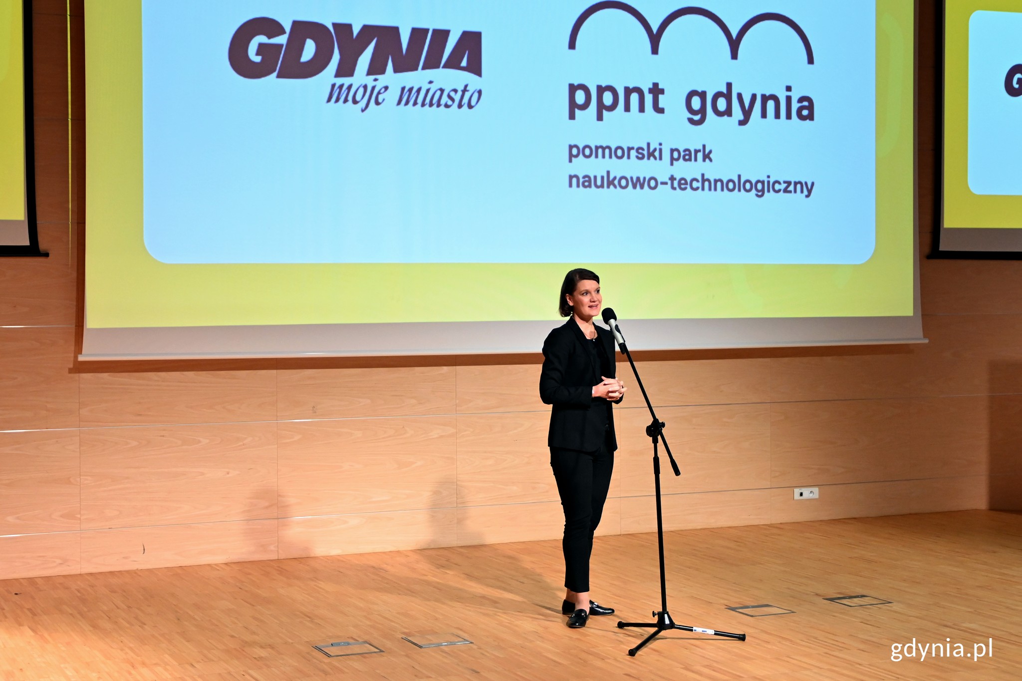 Wiceprezydent Gdyni Katarzyna Gruszecka-Spychała podczas gali otwarcia Gdynia Explory Week w Pomorskim Parku Naukowo-Technologicznym. W tle telebim z logo Gdyni i PPNT // fot. Magdalena Czernek