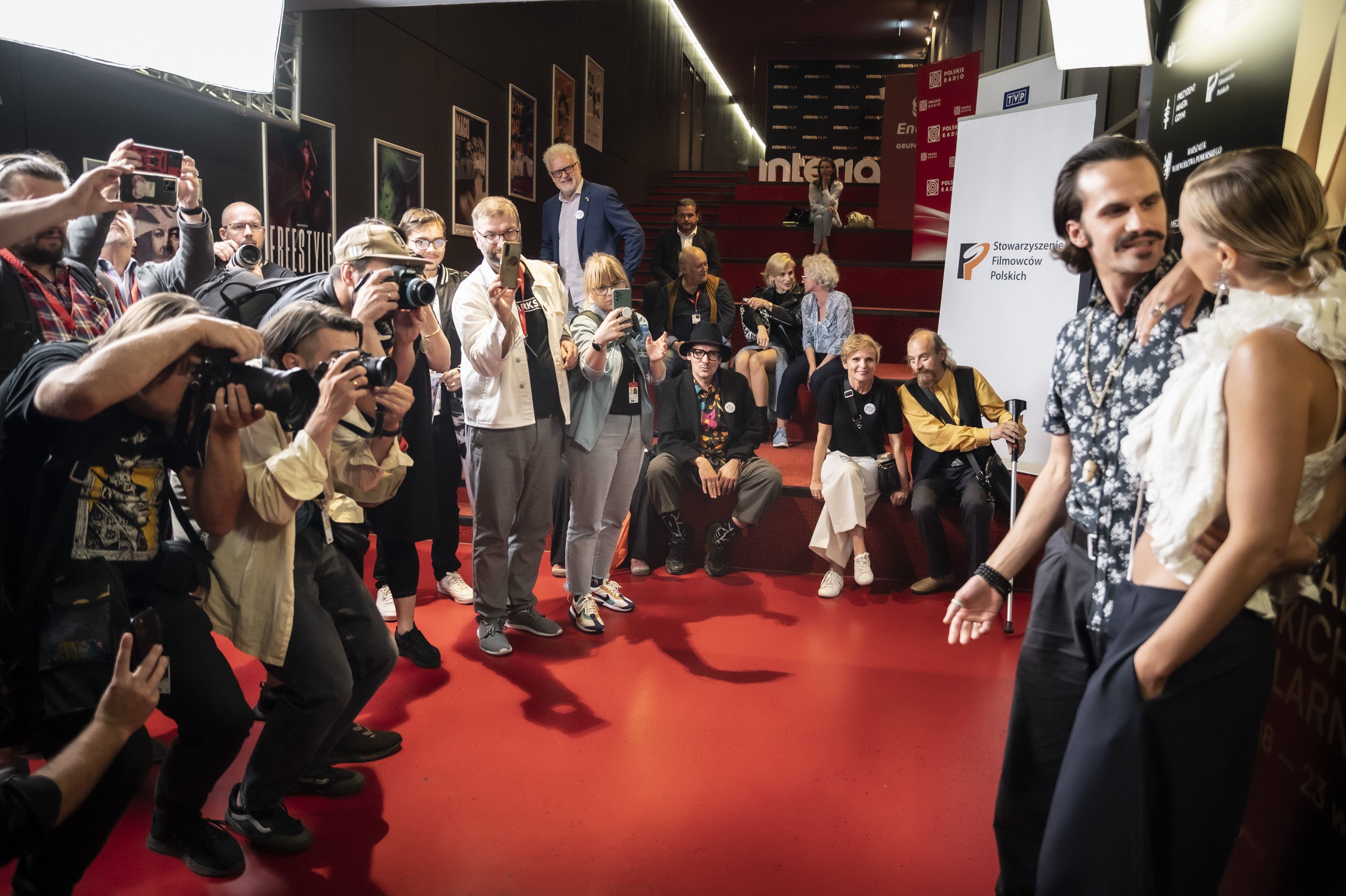 Czerwony dywan, ścianka, para aktorów pozuje fotografom