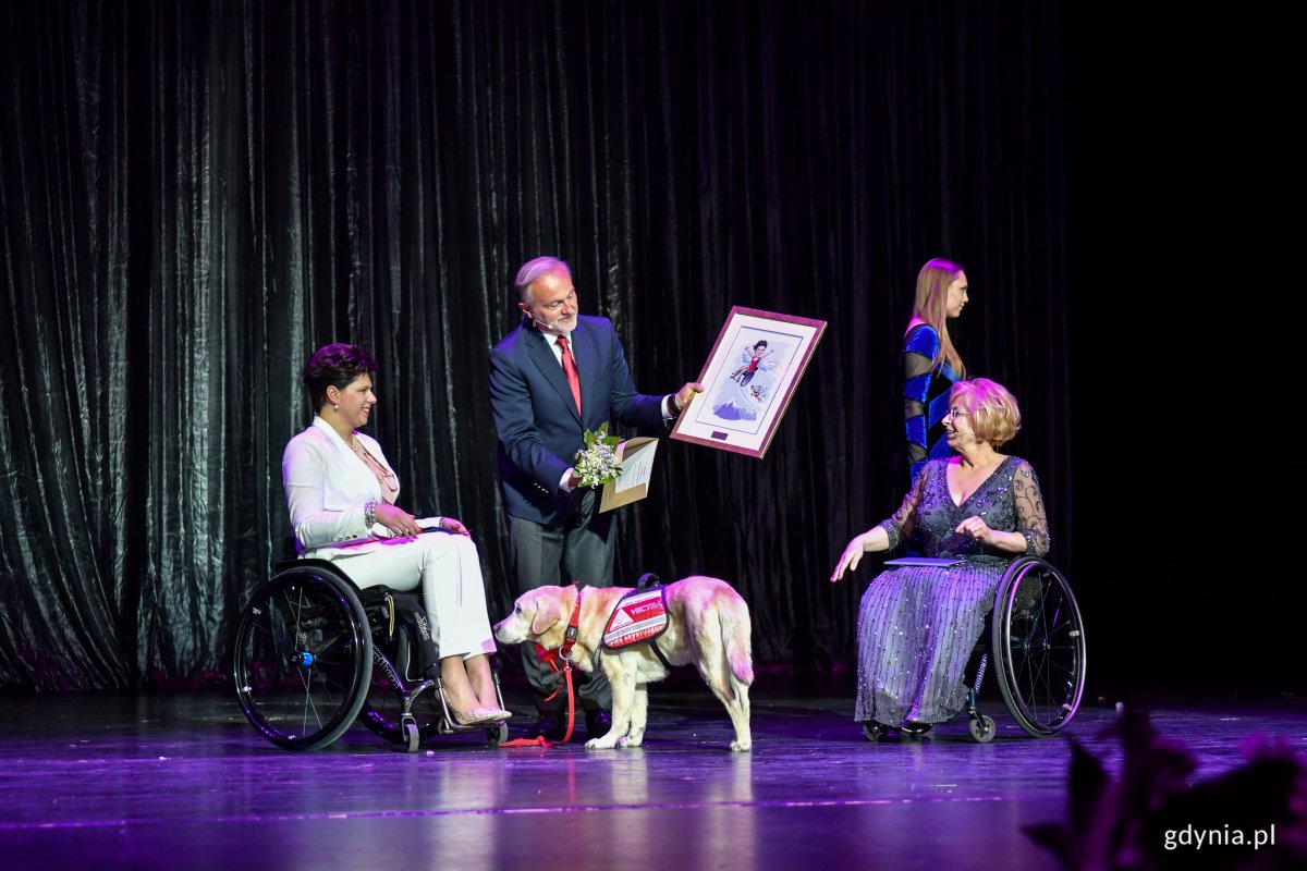 Gala 20. edycji konkursu „Gdynia bez barier”. Na scenie Anna Dobkowska odbiera medal z rąk prezydenta Wojciecha Szczurka oraz Beaty Wachowiak-Zwarry, pełnomocniczki prezydenta miasta Gdyni ds. osób z niepełnosprawnością. Fot. Dawid Linkowski