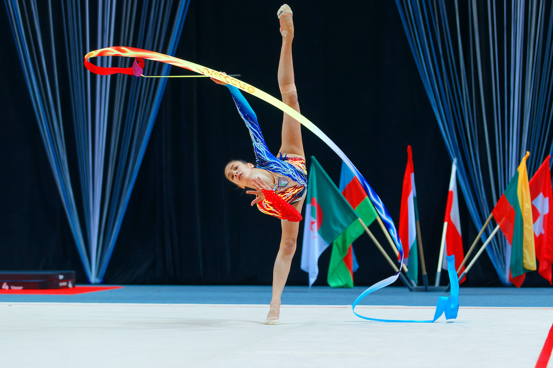 Sofia Raffaeli podczas pokazu - gimnastyczka z wstążką z uniesioną do góry nogą