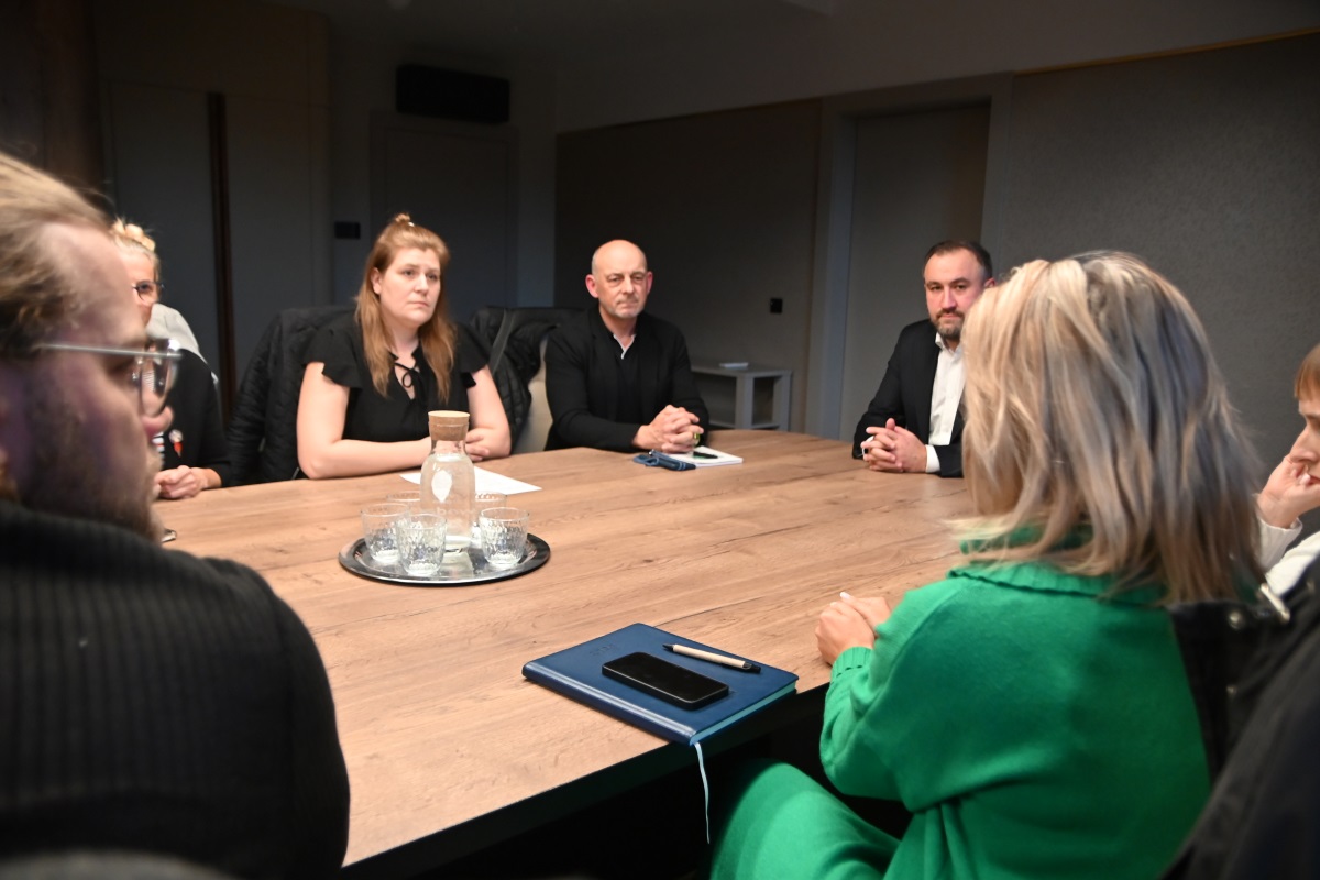 Grupa osób rozmawiająca przy stole