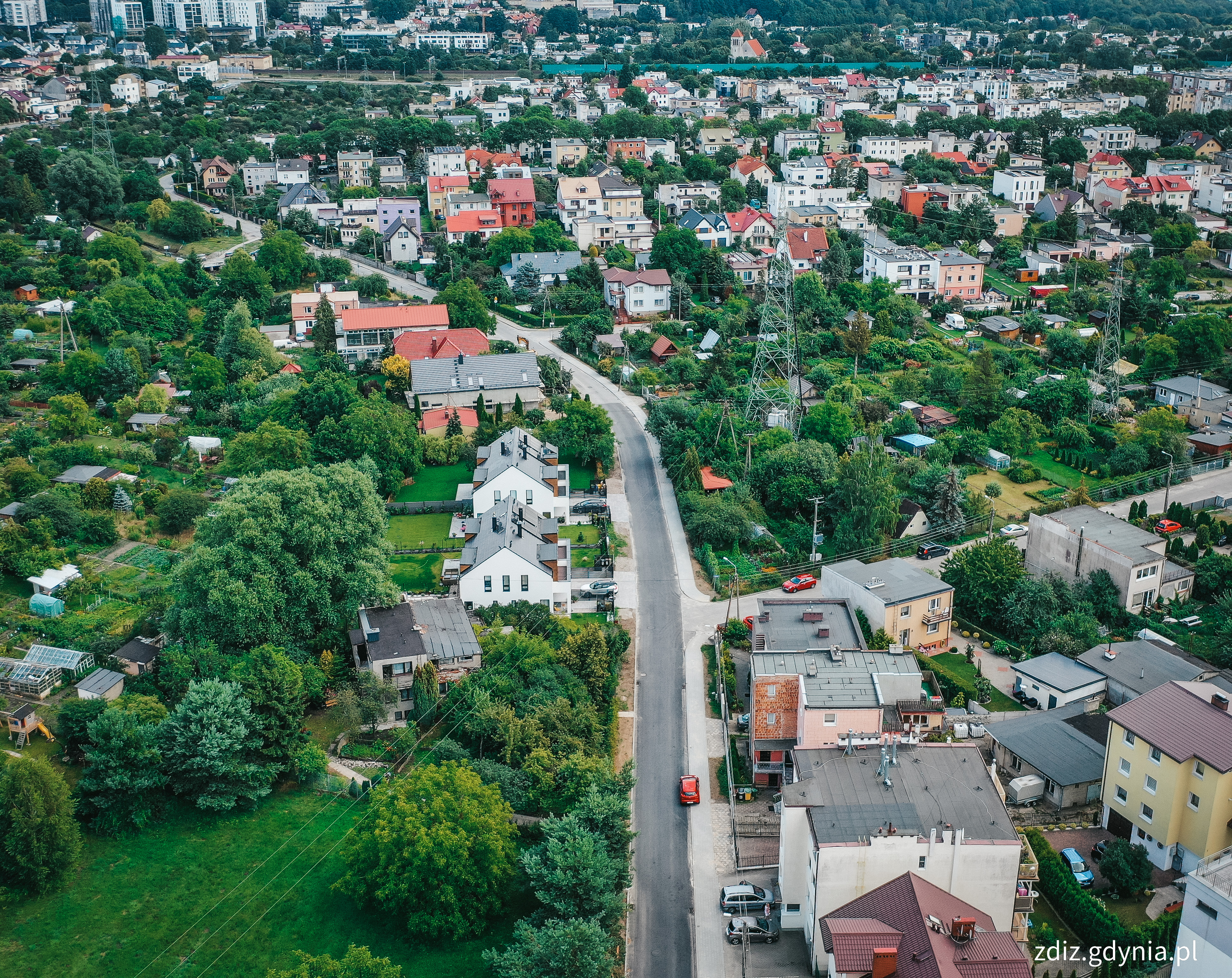 widok z góry na wyremontowany fragment drogi, widoczna nawierzchnia, zieleń i budynki