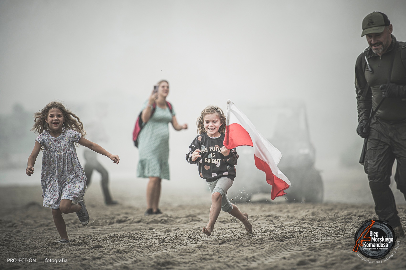 Biegnące dzieci z flagą Polski podczas Biegu Morskiego Komandosa w Gdyni