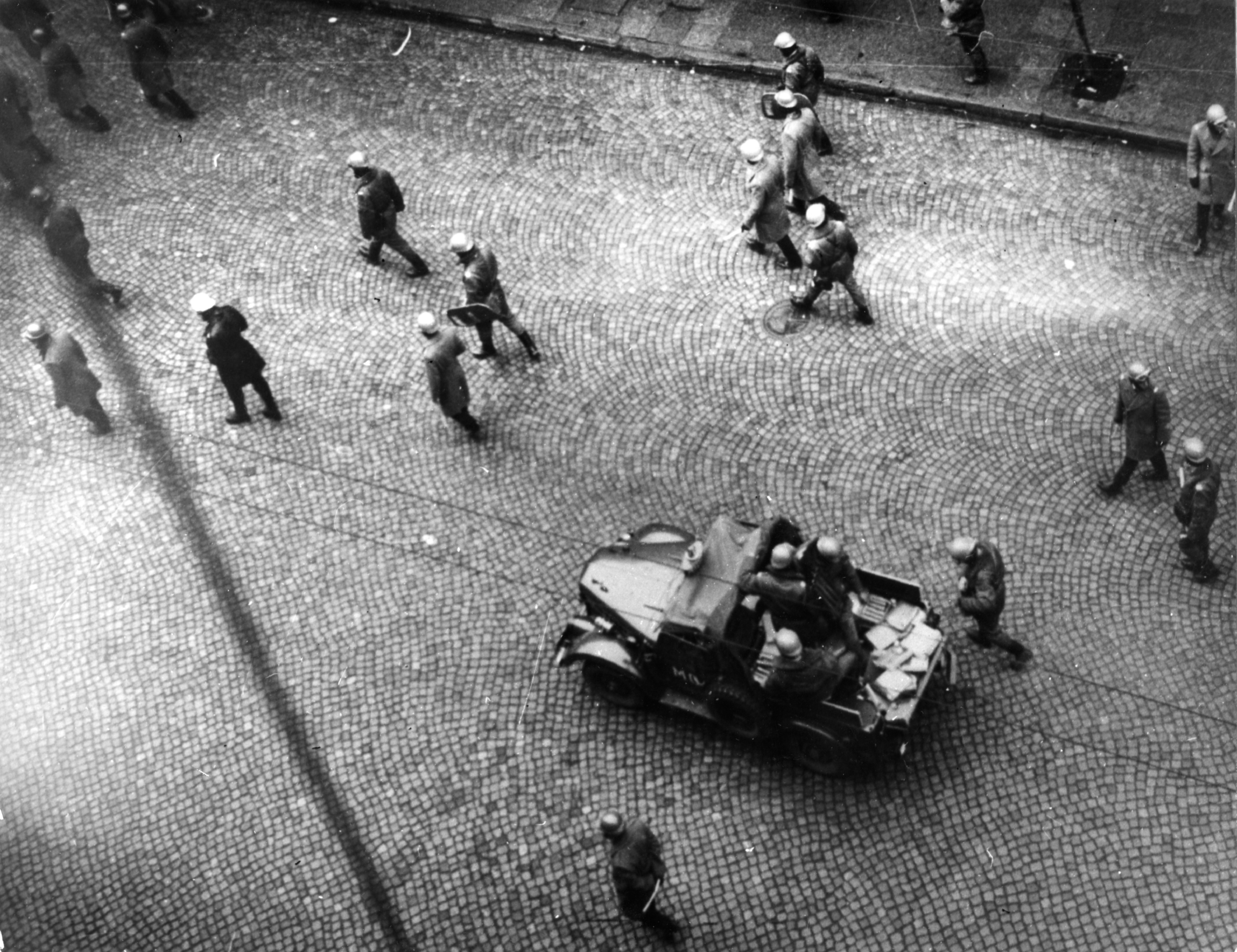 Milicjanci na ulicy Świętojańskiej w Gdyni podczas zamieszek.  Na samochodzie widać prawdopodobnie czterolufowy wyrzutnik gazu łzawiącego WŁ-1 // źródło: IPN