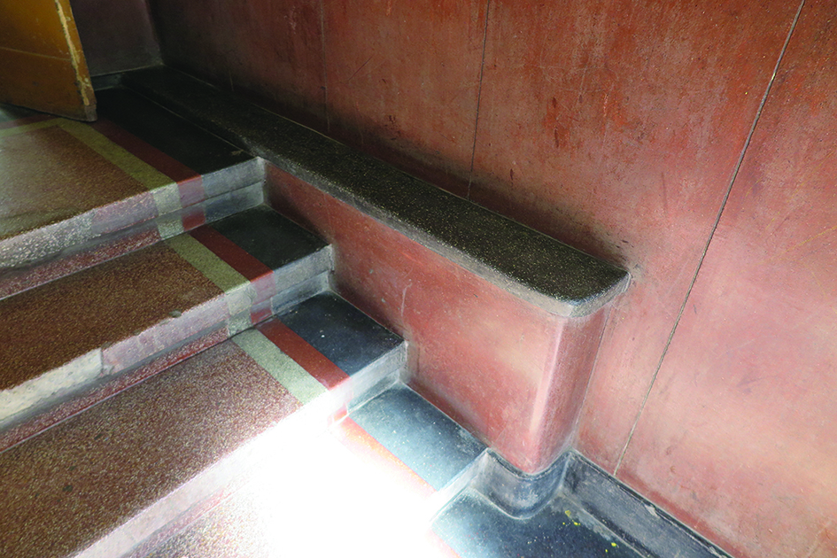 Fragment strefy wejściowej w kamienicy przy ul. Bema 15, dolne partie ścian oraz posadzka wykonana z lastryka o intensywnych kolorach.