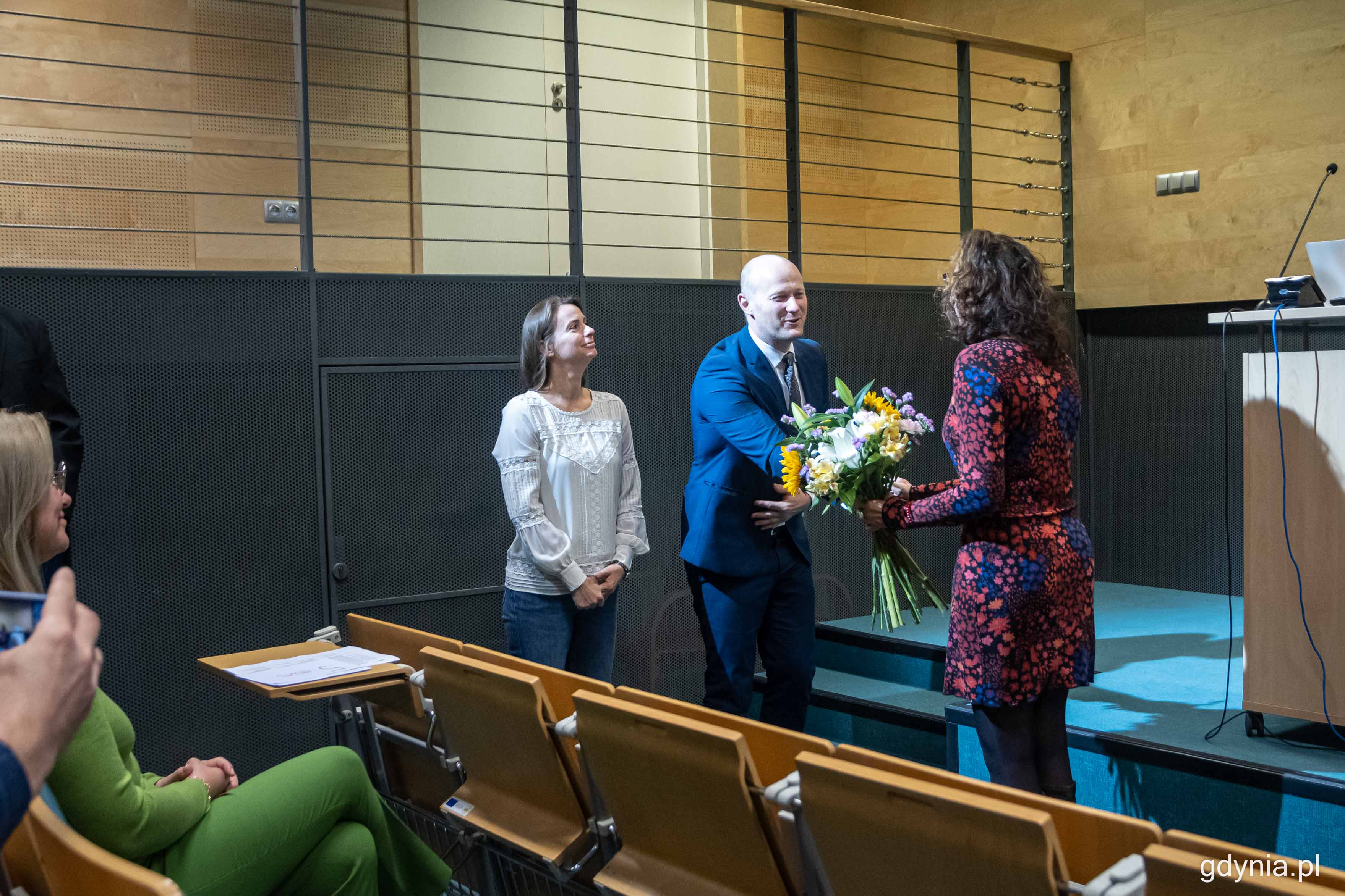 Dyrektor Ośrodka Profilaktyki i Terapii Uzależnień w Gdyni, Katarzyna Wiśniewska (z prawej) odbiera symboliczne gratulacje od wiceprezydenta Gdyni Bartosza Bartoszewicza (w środku), fot. Kamil Złoch