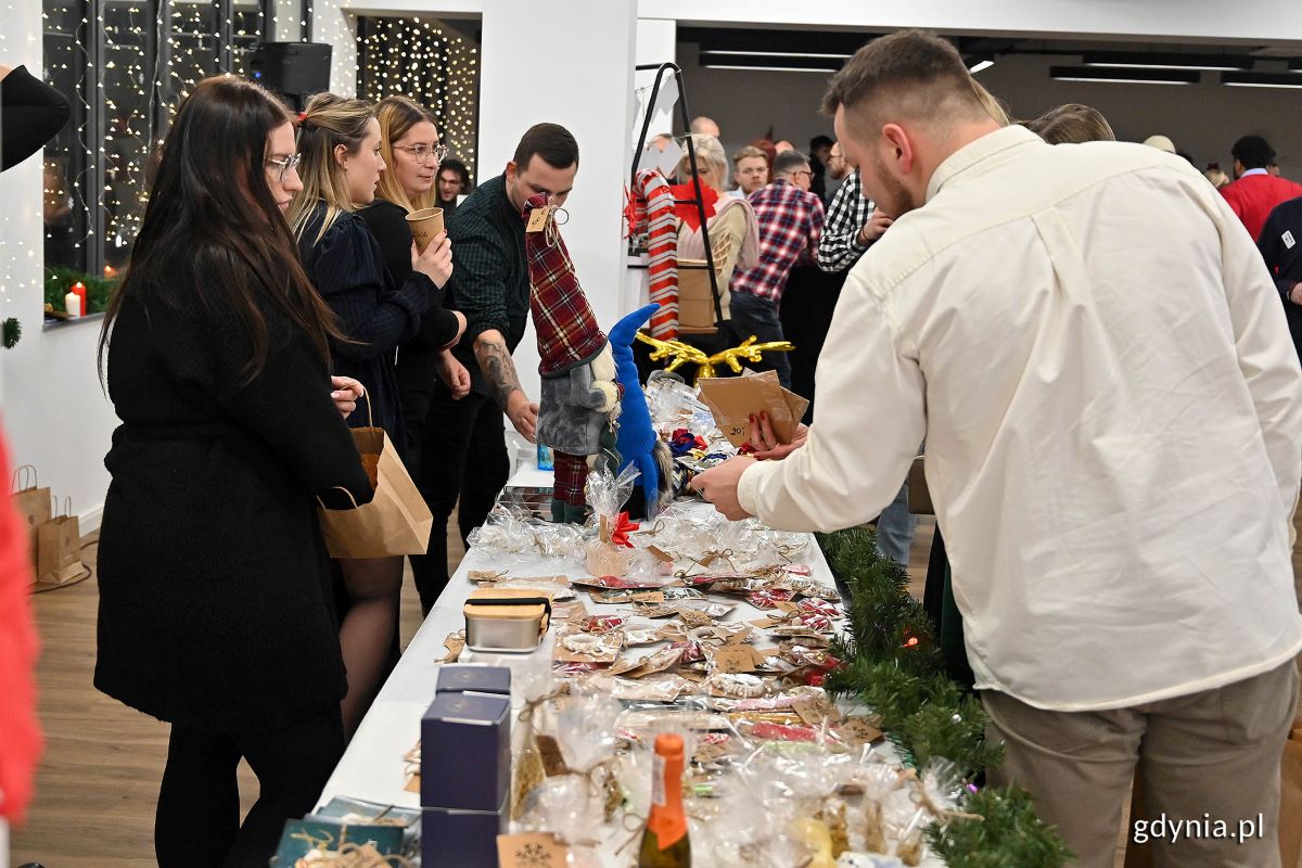 Zdjęcie przedstawia grupę os&oacute;b obecną na świątecznym kiermaszu Stowarzyszenia BFI Cares