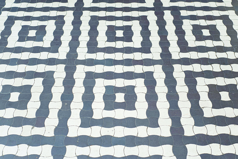 Posadzka w holu budynku na Działkach Leśnych, geometryczny motyw dekoracyjny skomponowany z czarno-białych gorsecik&oacute;w