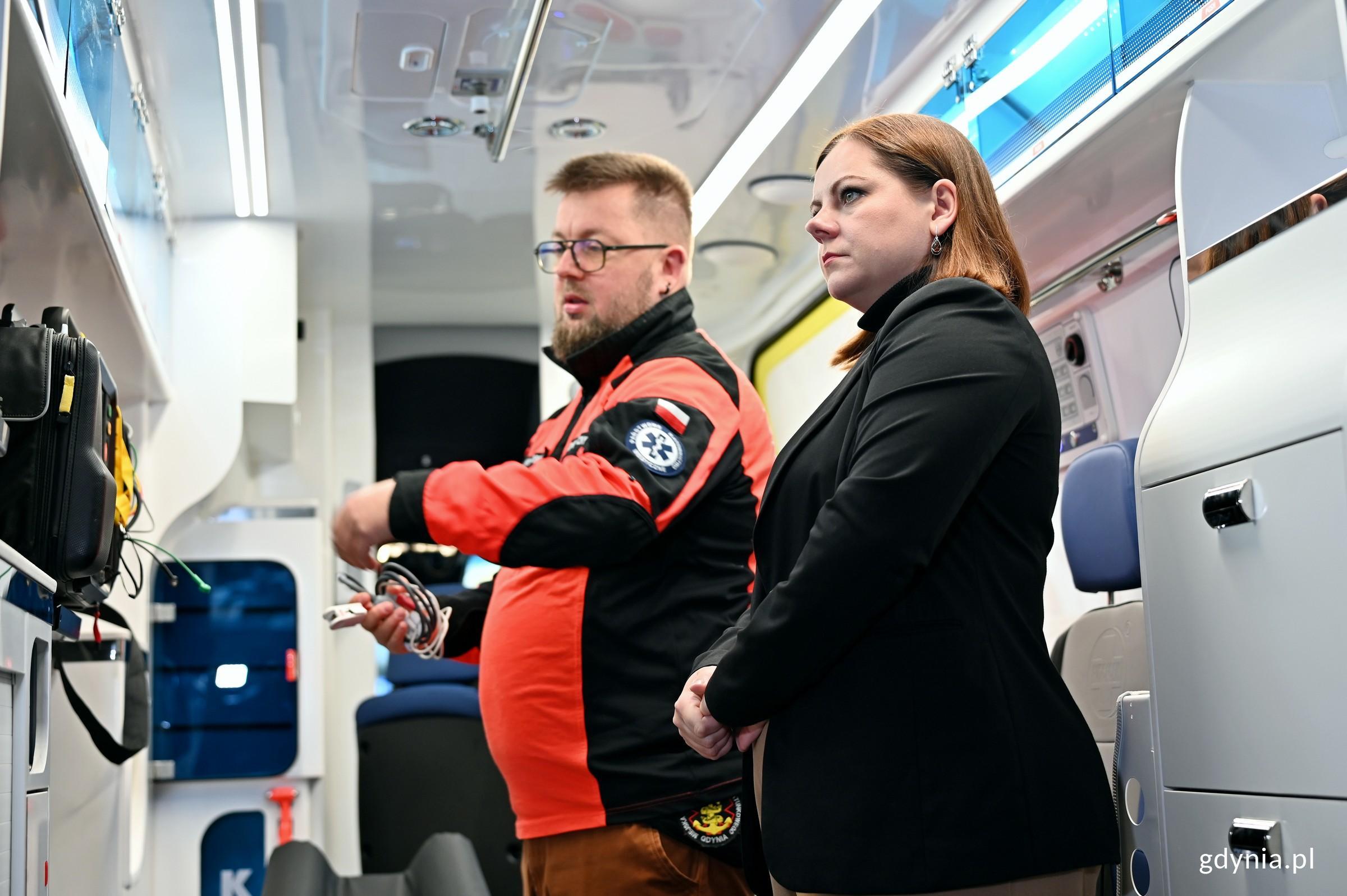 Prezydent Gdyni Aleksandra Kosiorek przyglądająca się specjalistycznemu wyposażeniu jednej z nowych karetek w towarzystwie ratownika medycznego (fot. Magdalena Czernek)
